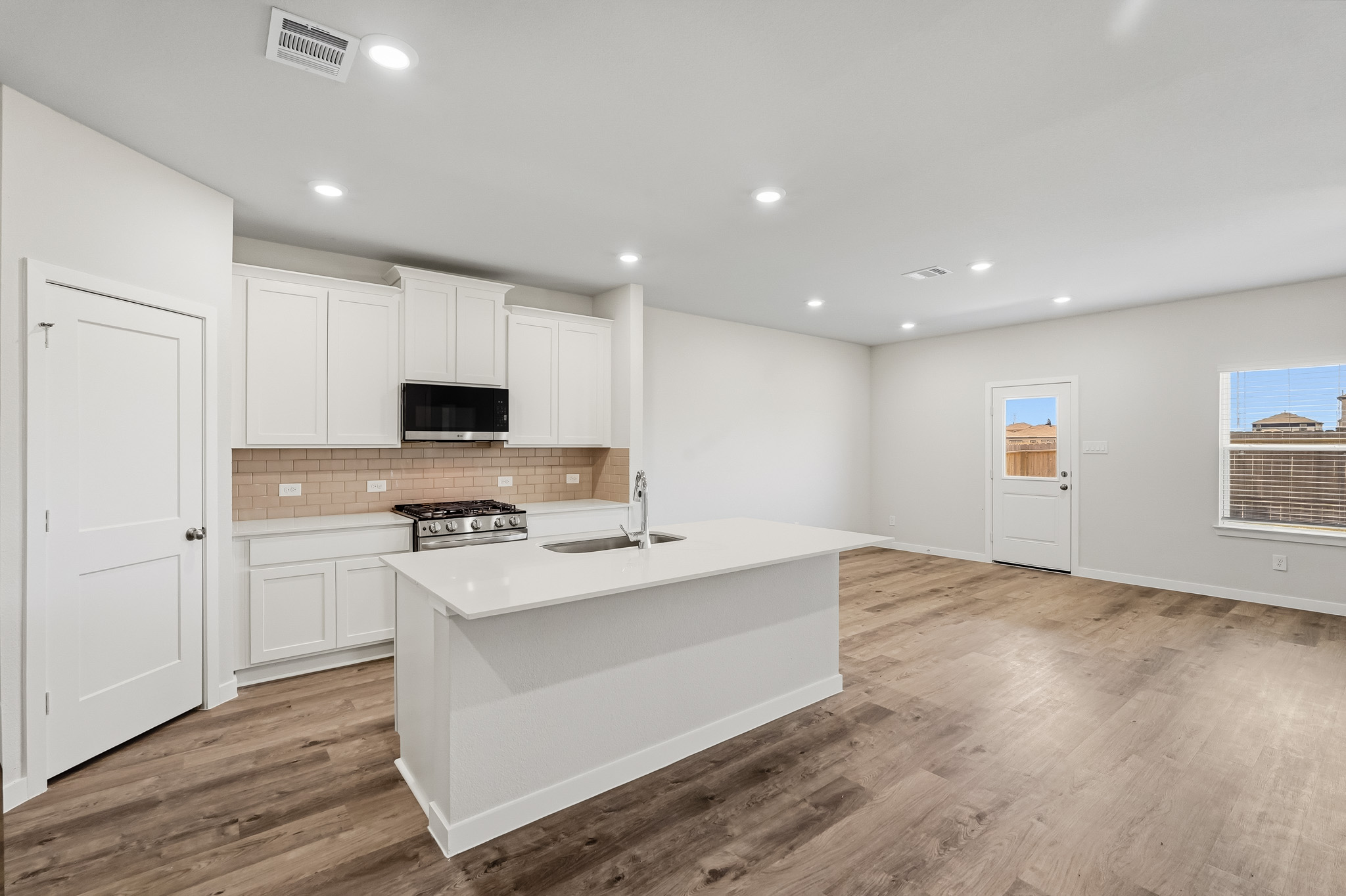 A kitchen with white cabinets.
