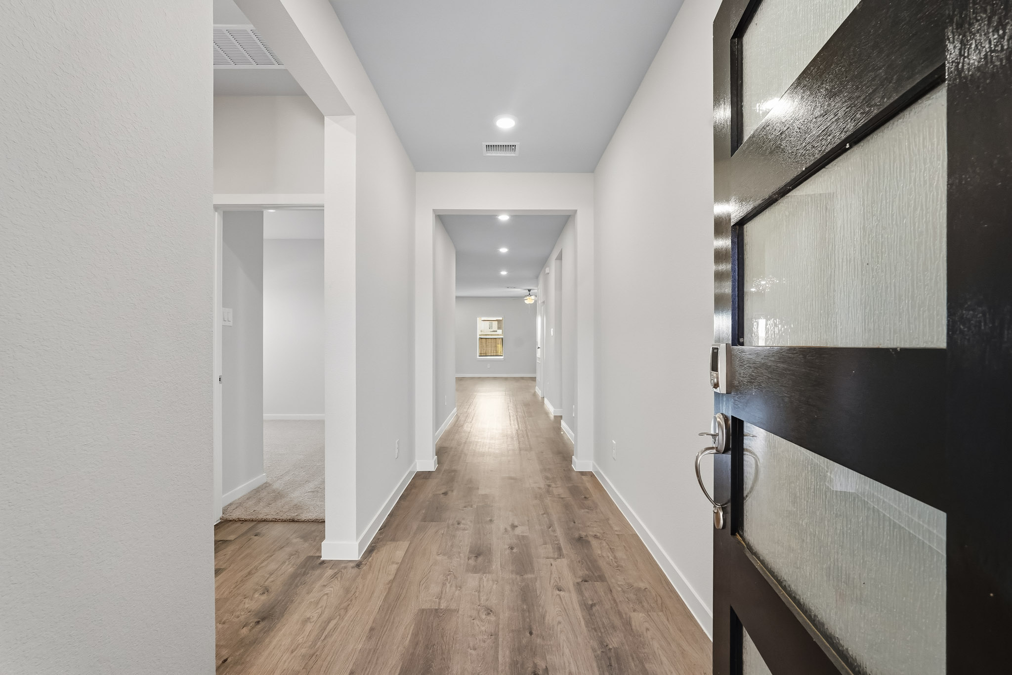 A long hallway with black cabinets.