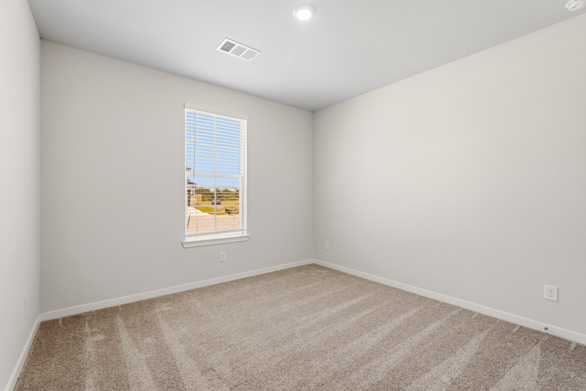 A room with a window and a carpet.