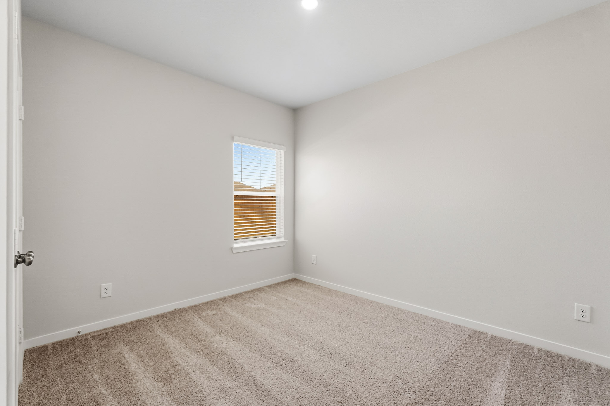 A room with a window and carpet.