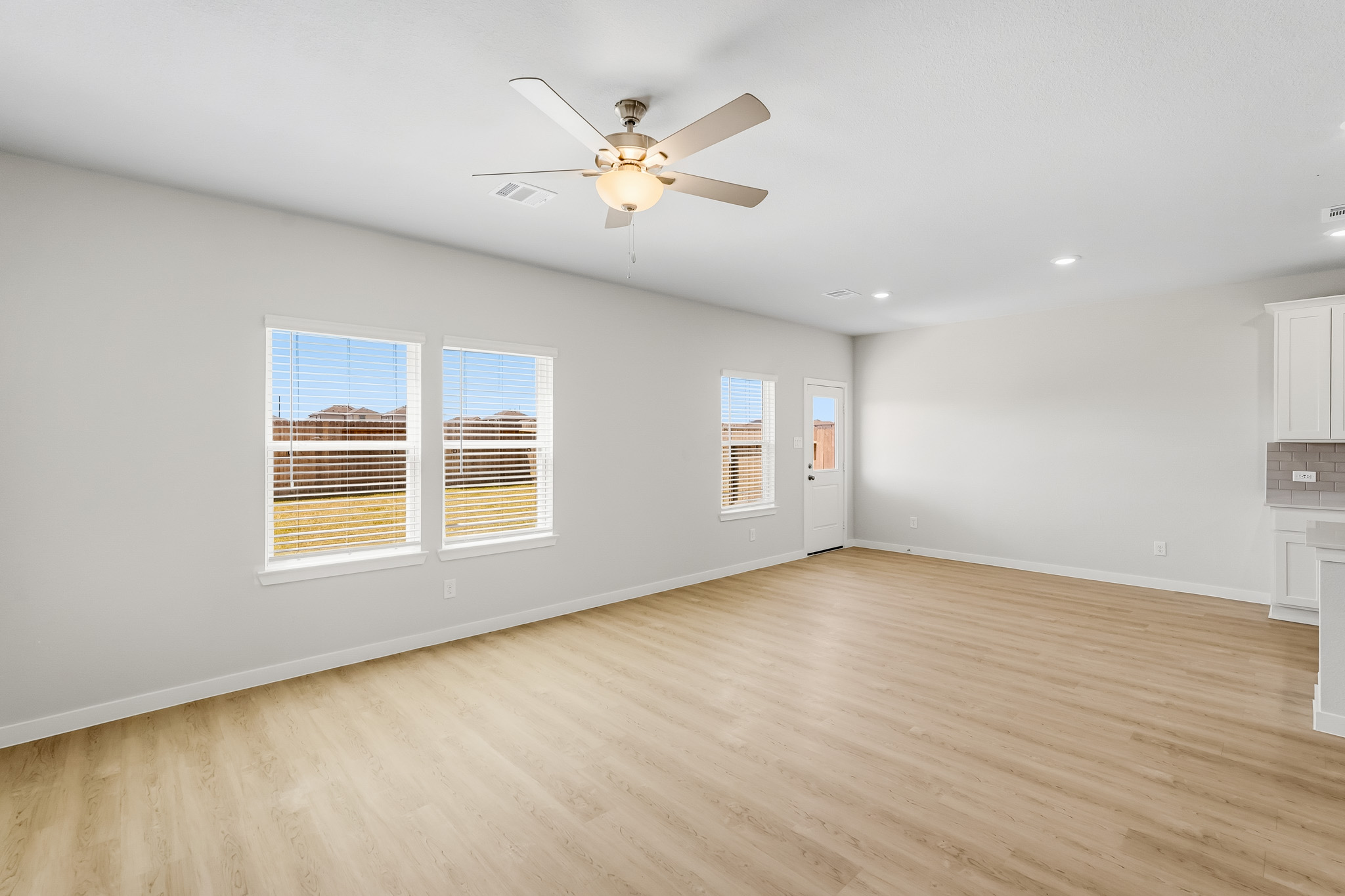 A room with a wood floor and a ceiling fan.