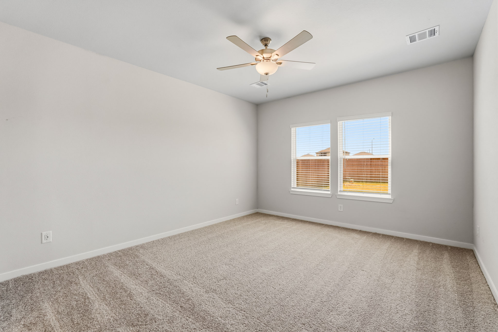 A room with a ceiling fan and a window.