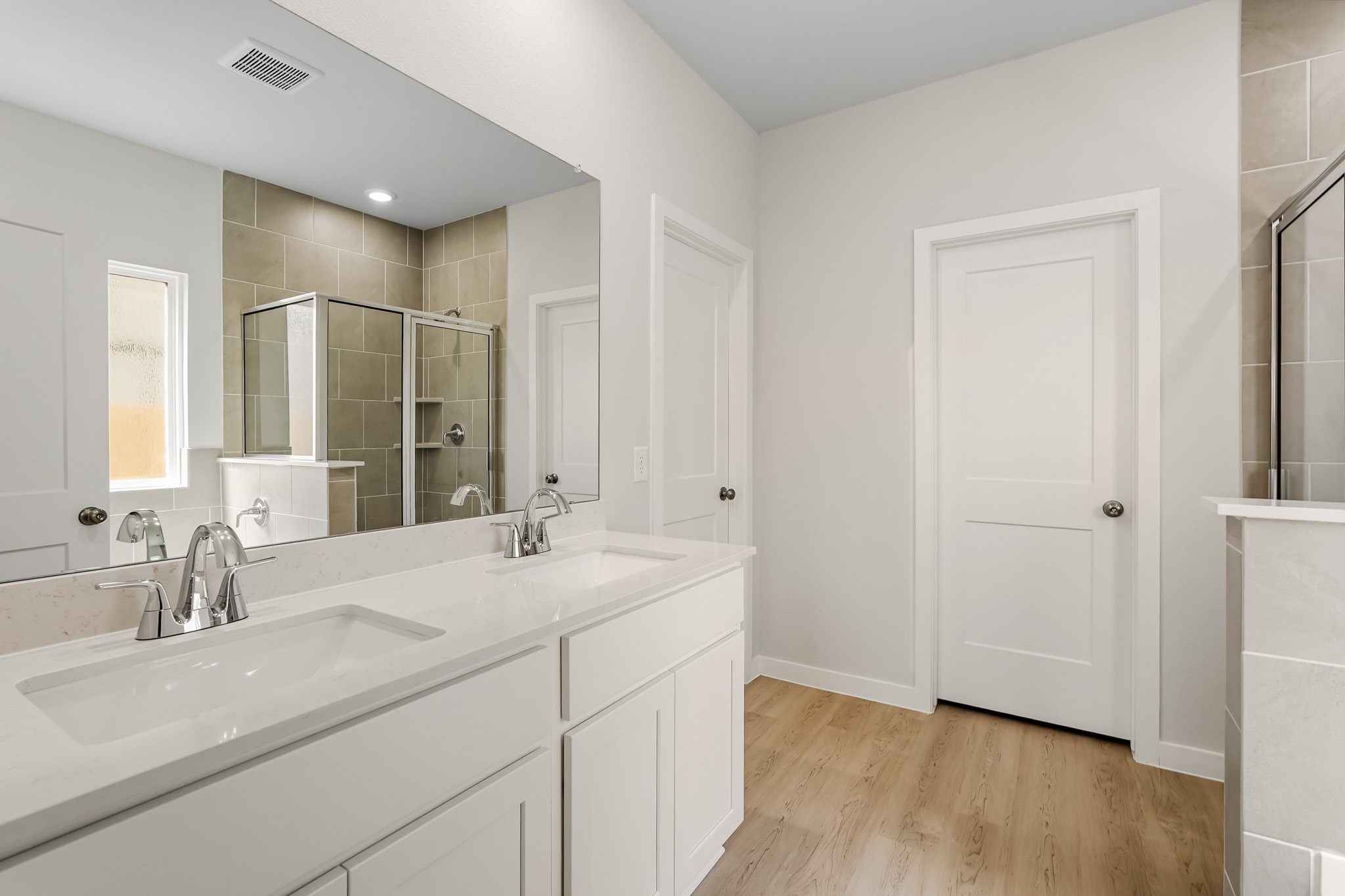 A bathroom with white cabinets.