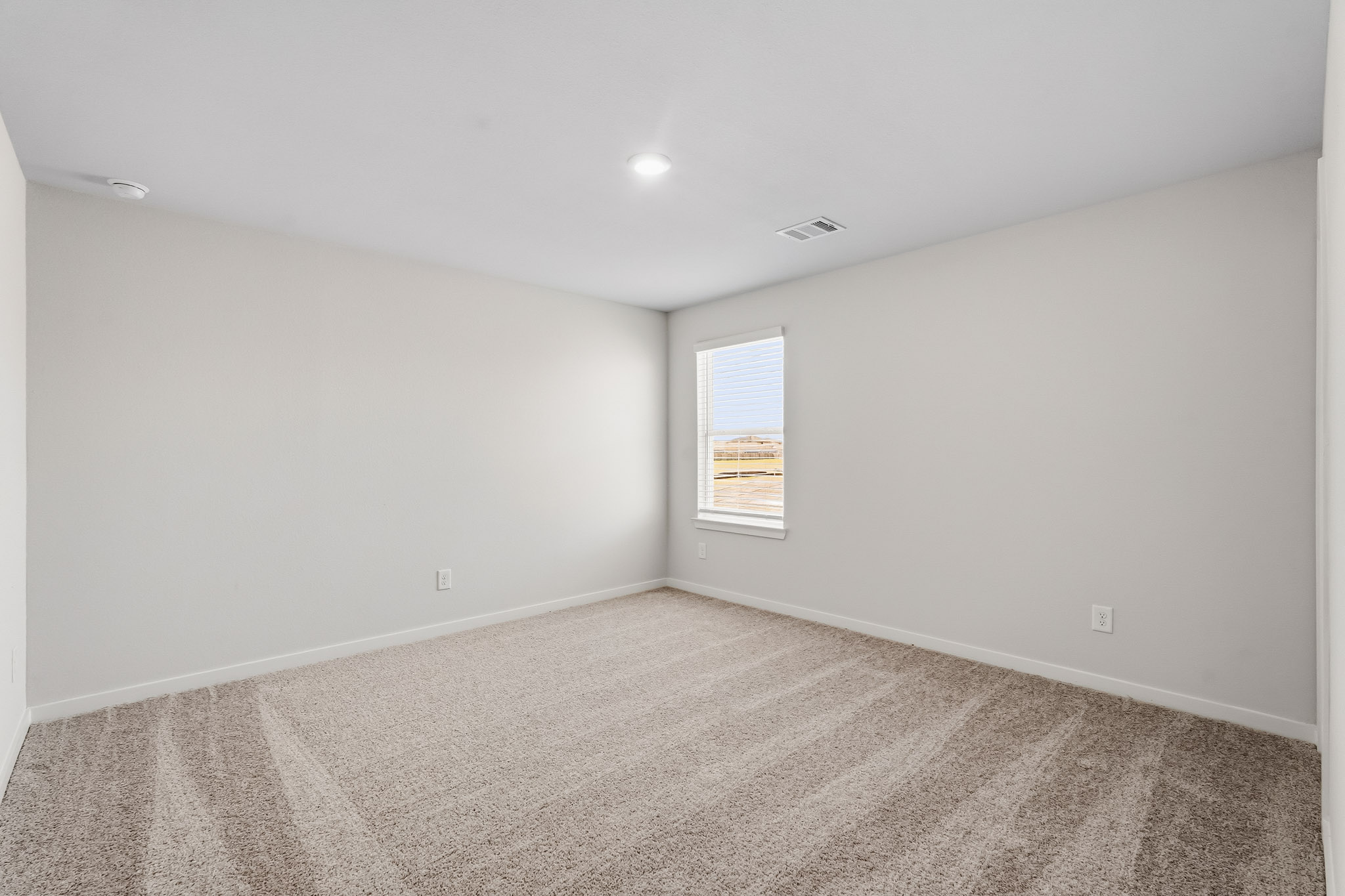 A room with a carpet and a window.