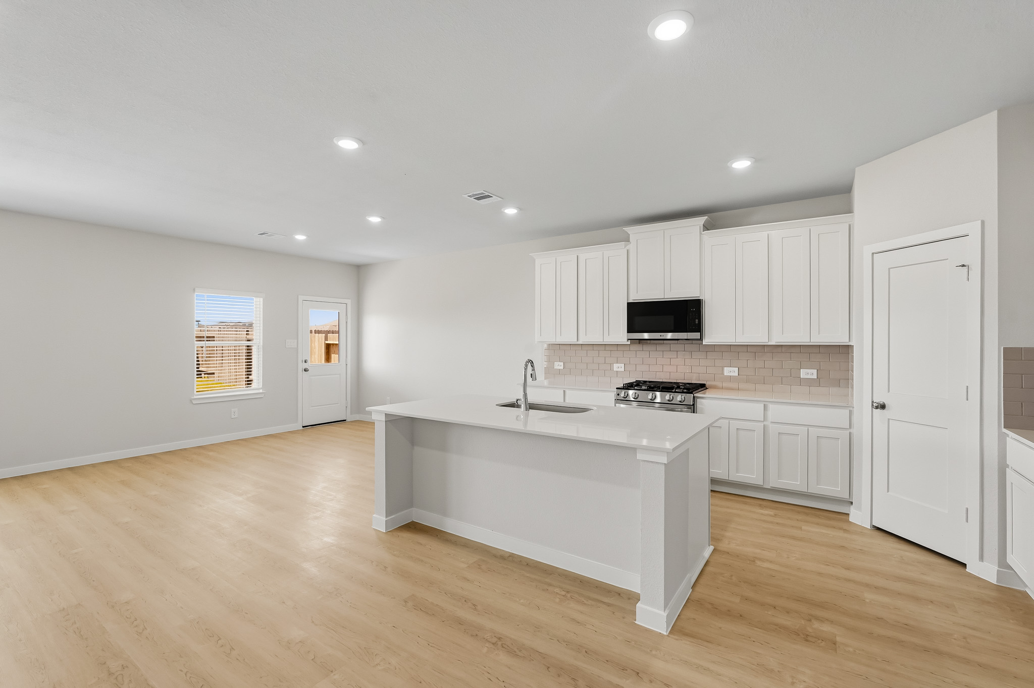 A kitchen with white cabinets.