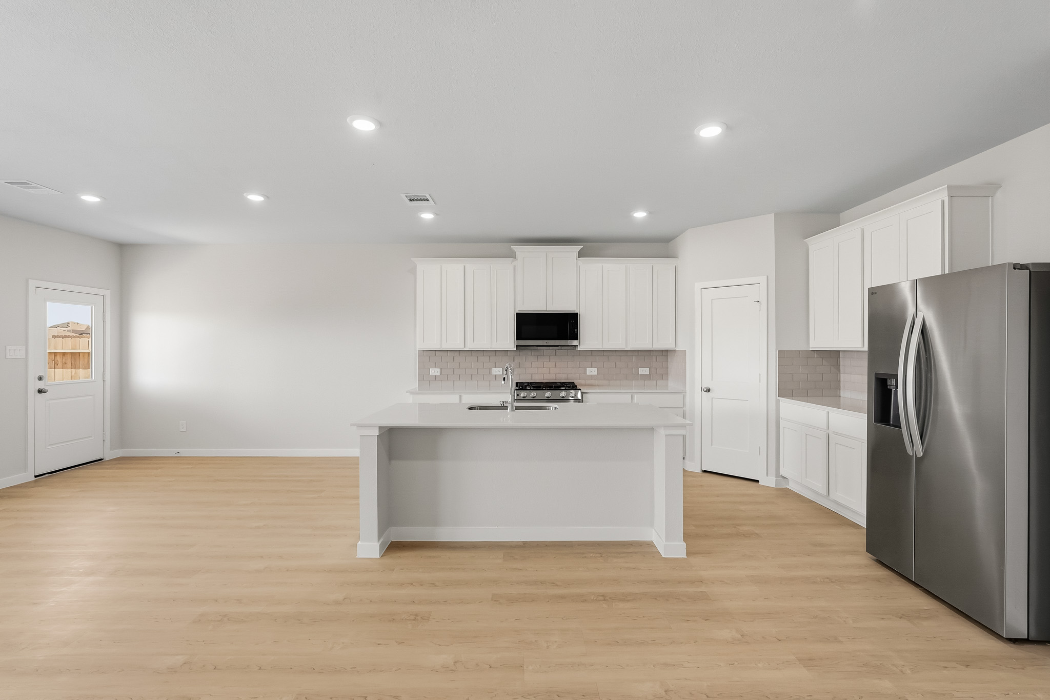 A kitchen with white cabinets.