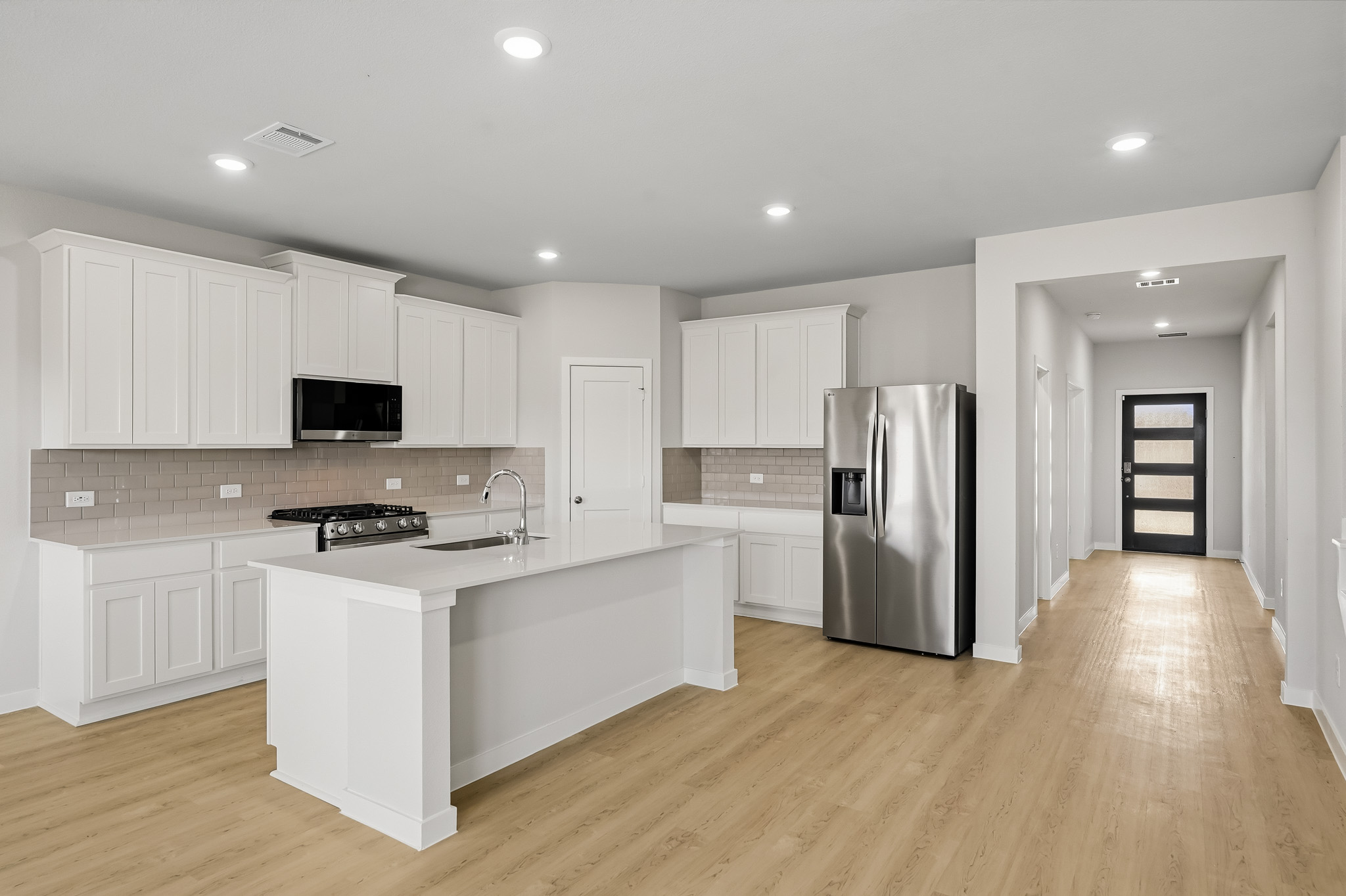 A kitchen with white cabinets.