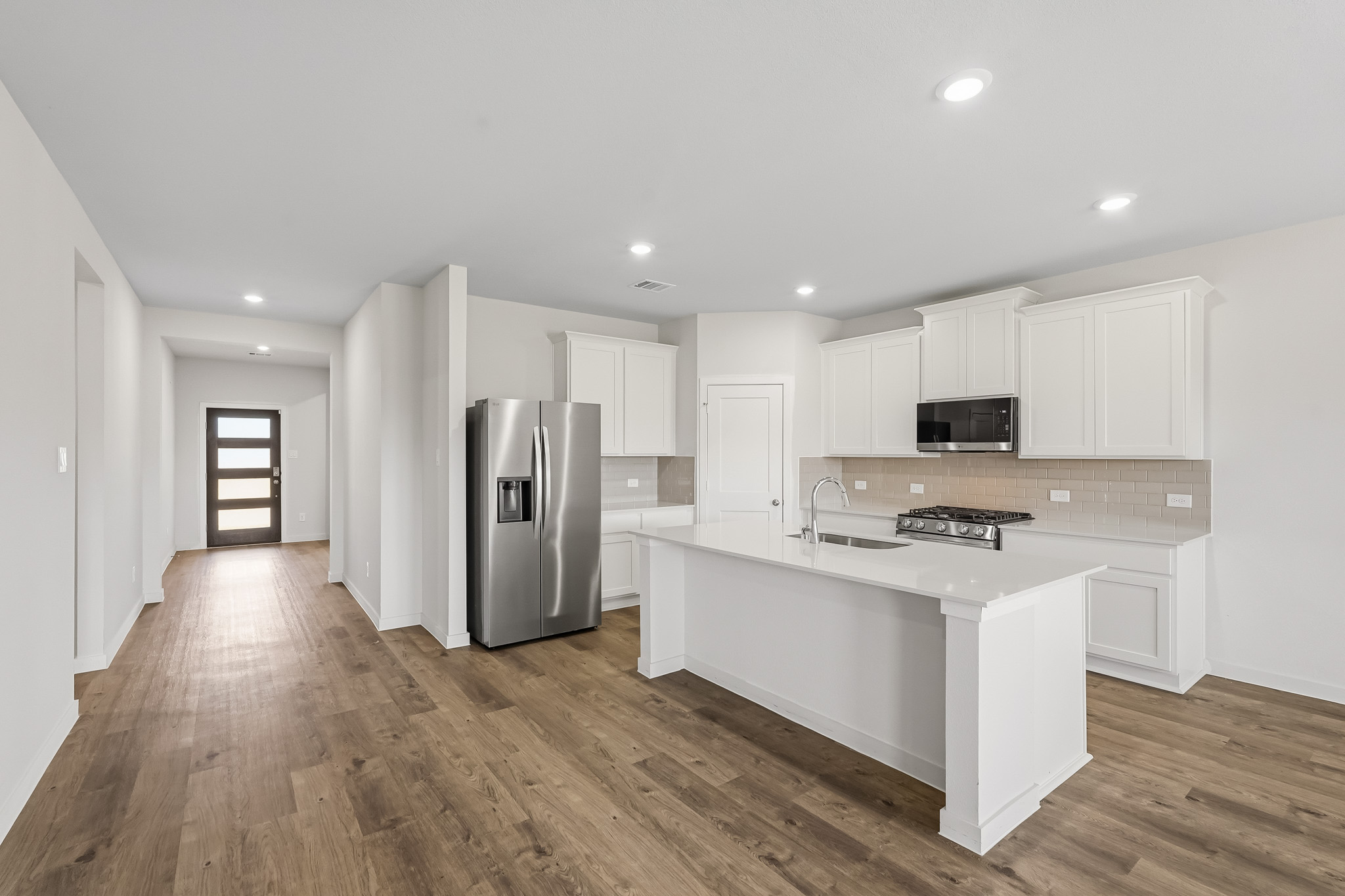 A kitchen with white cabinets.