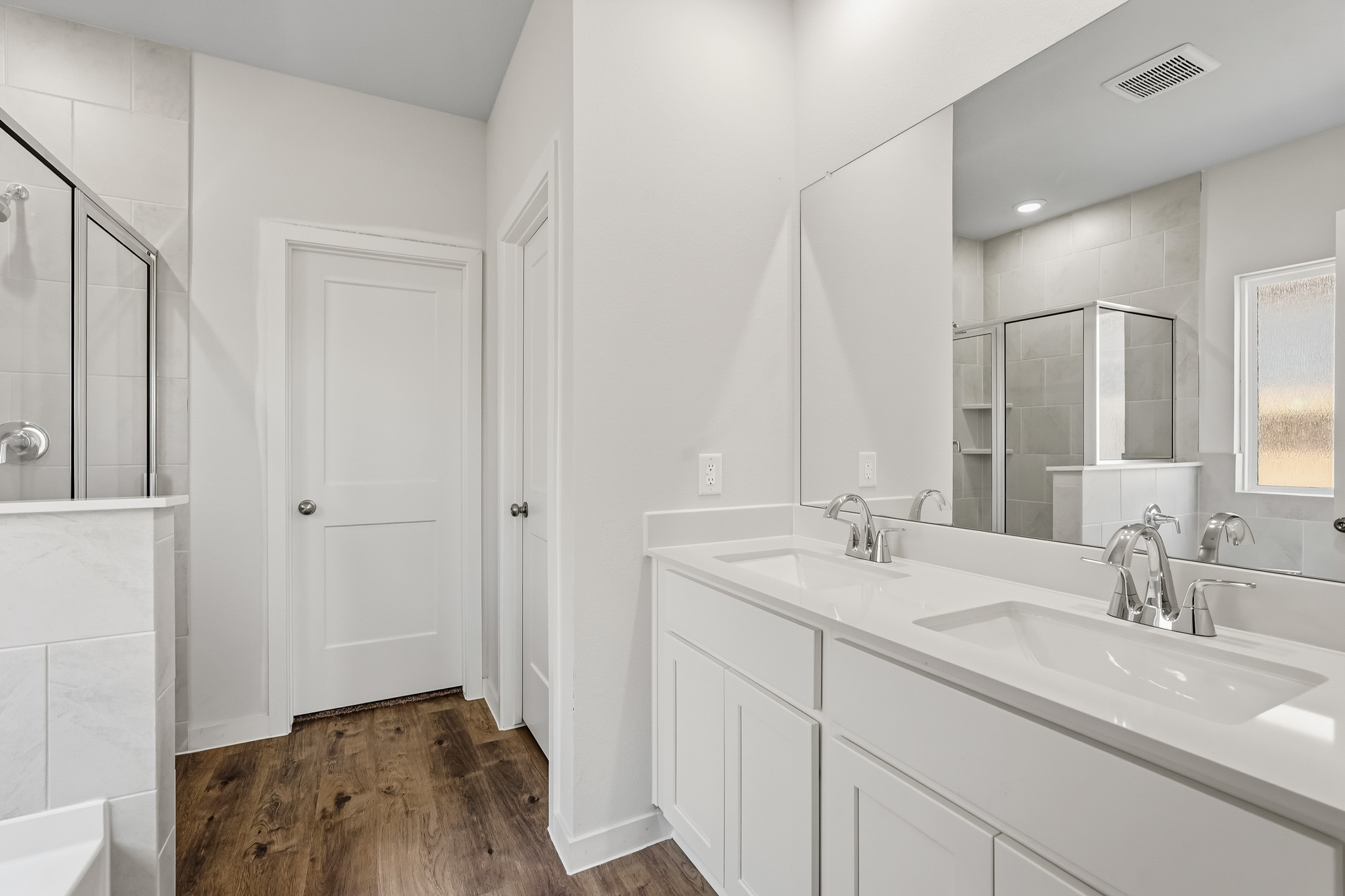 A bathroom with white cabinets.