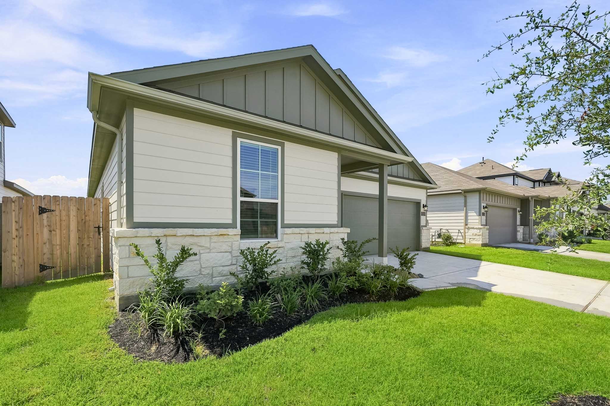 A house with a fence and bushes.