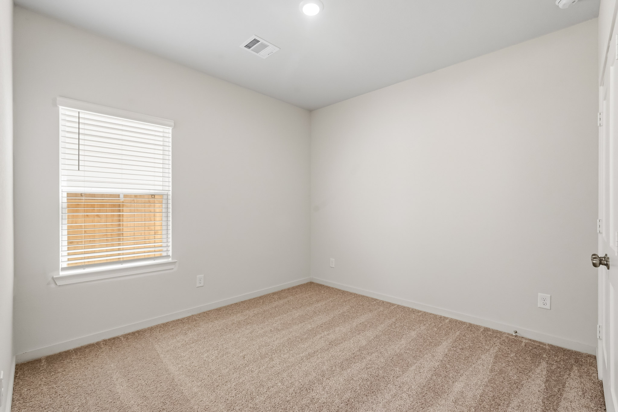 A room with a carpet and a window.