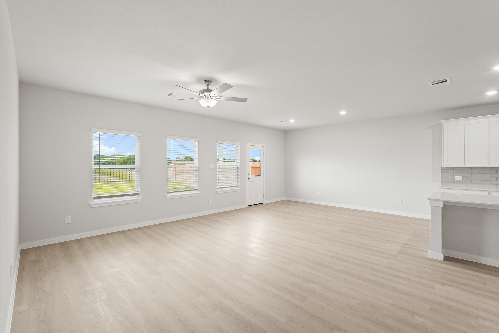 A room with a wood floor and a ceiling fan.