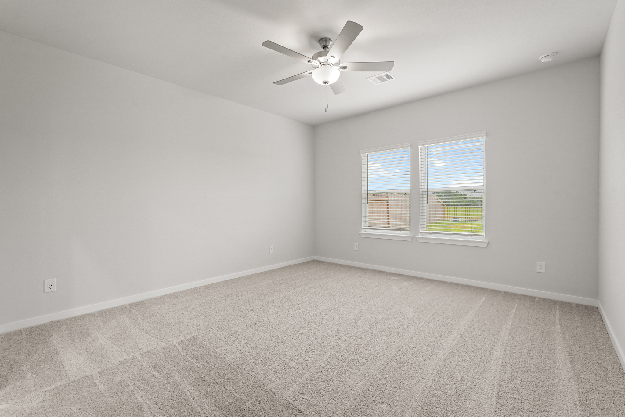 A room with a ceiling fan and a window.
