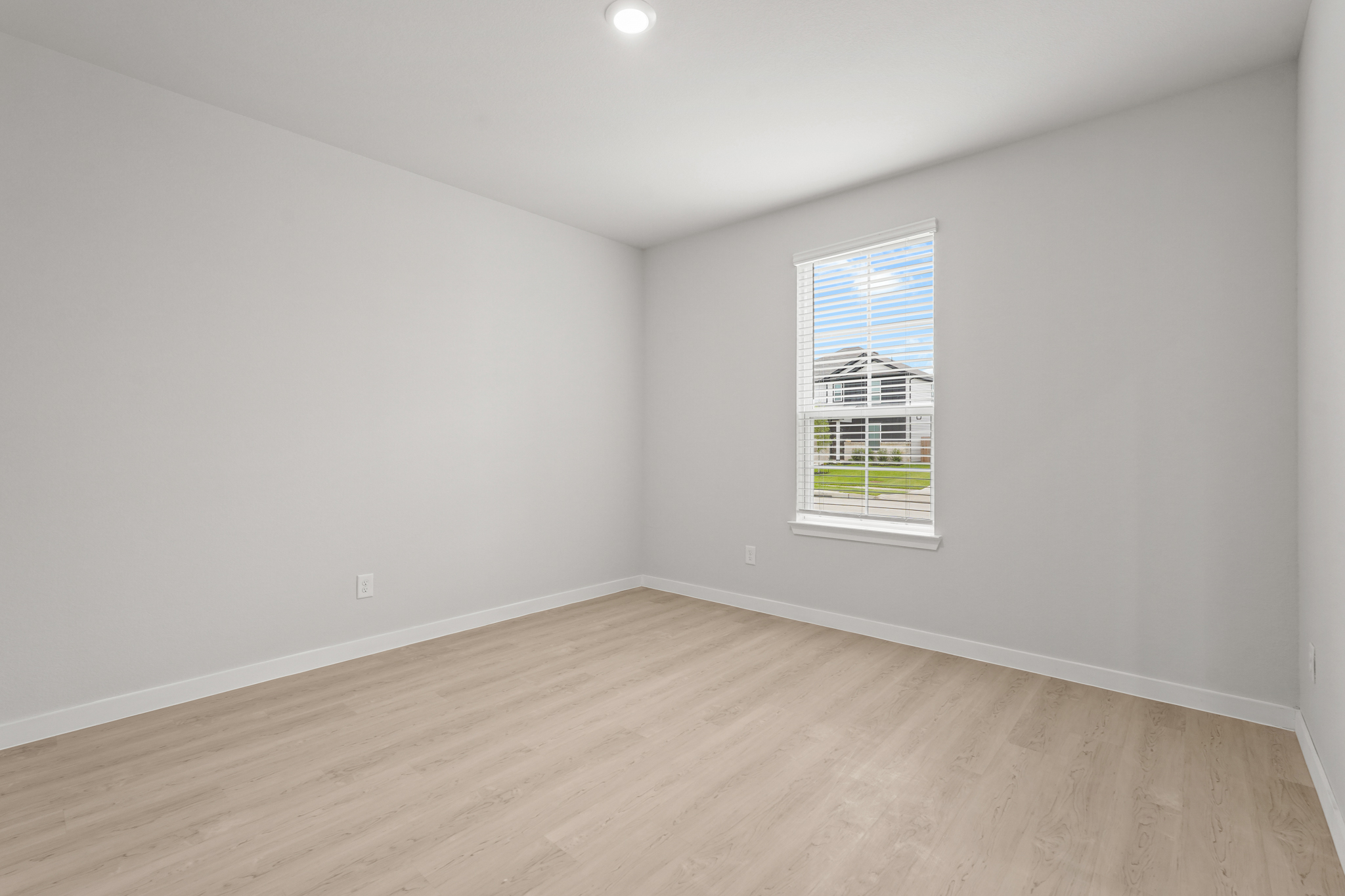A room with a wood floor and a window.
