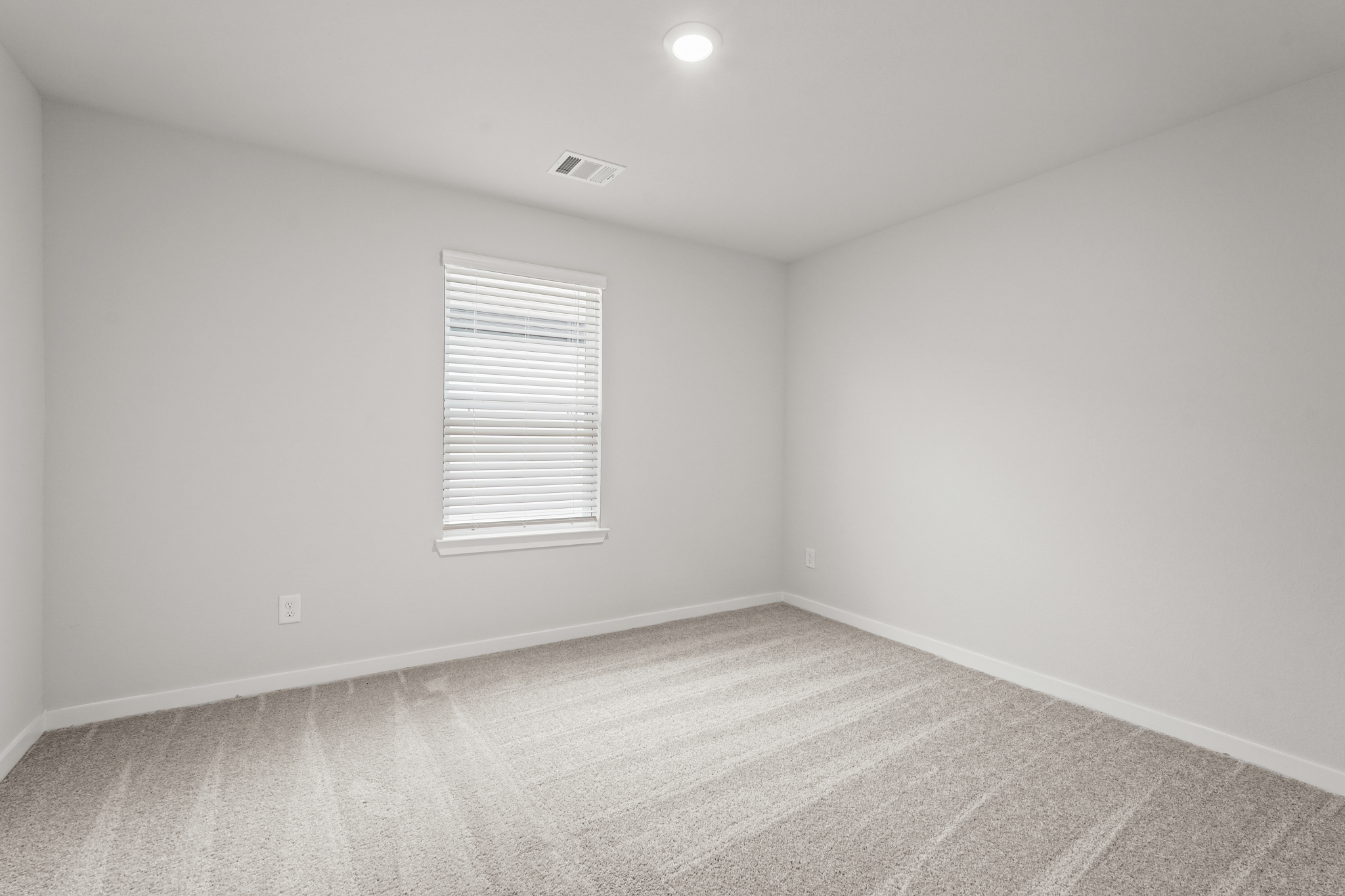 A room with a window and a carpet.
