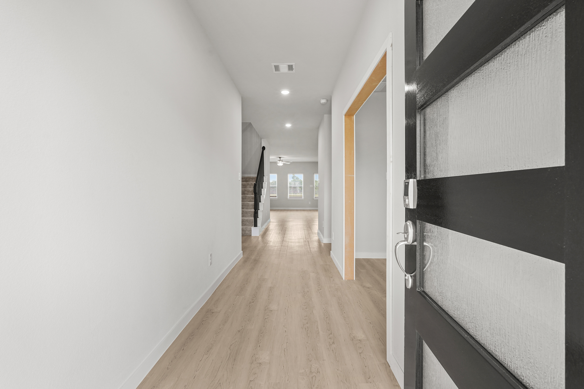 A hallway with black cabinets.