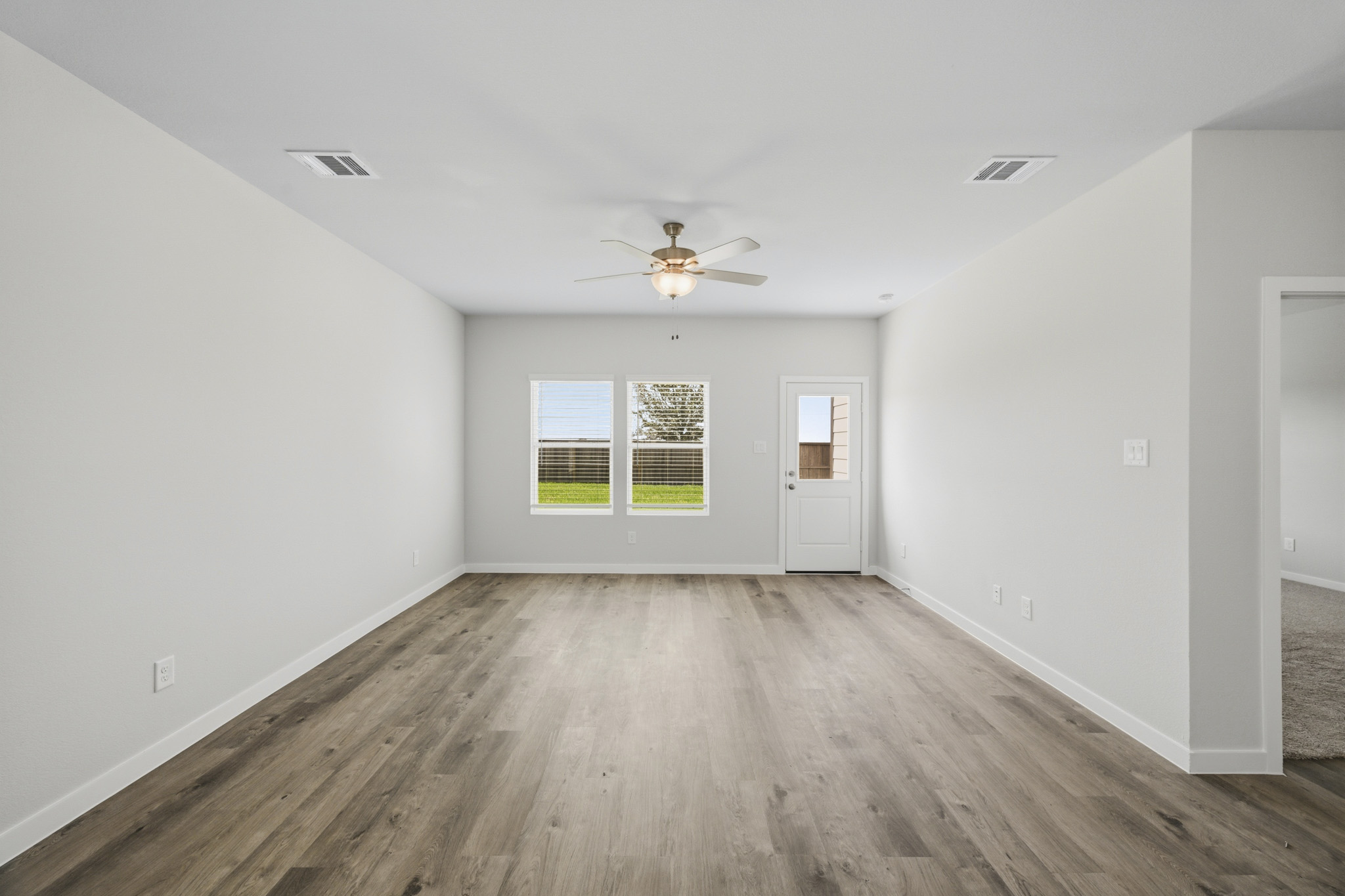 A room with a wood floor and a ceiling fan.
