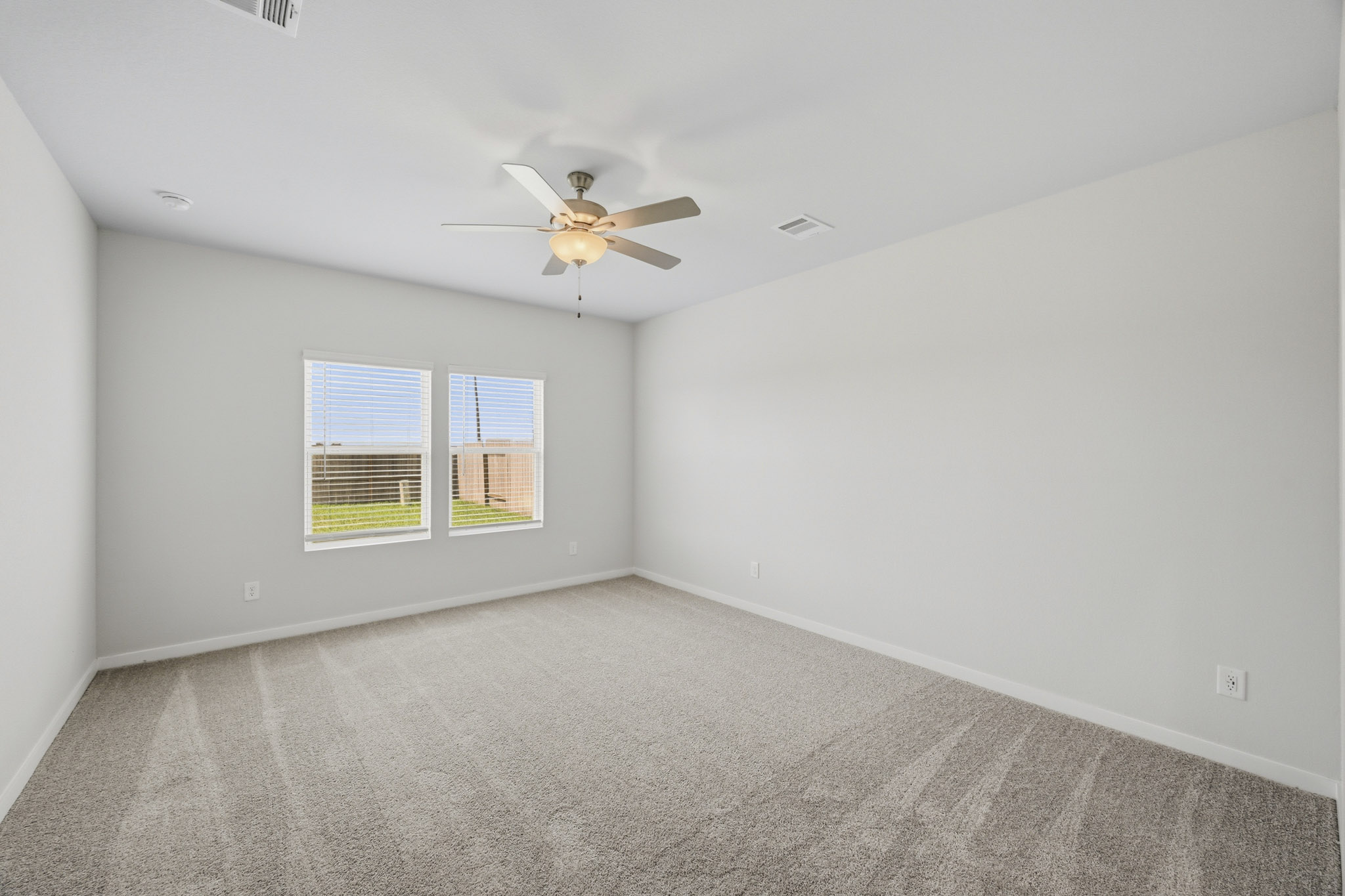 A room with a ceiling fan and a window.