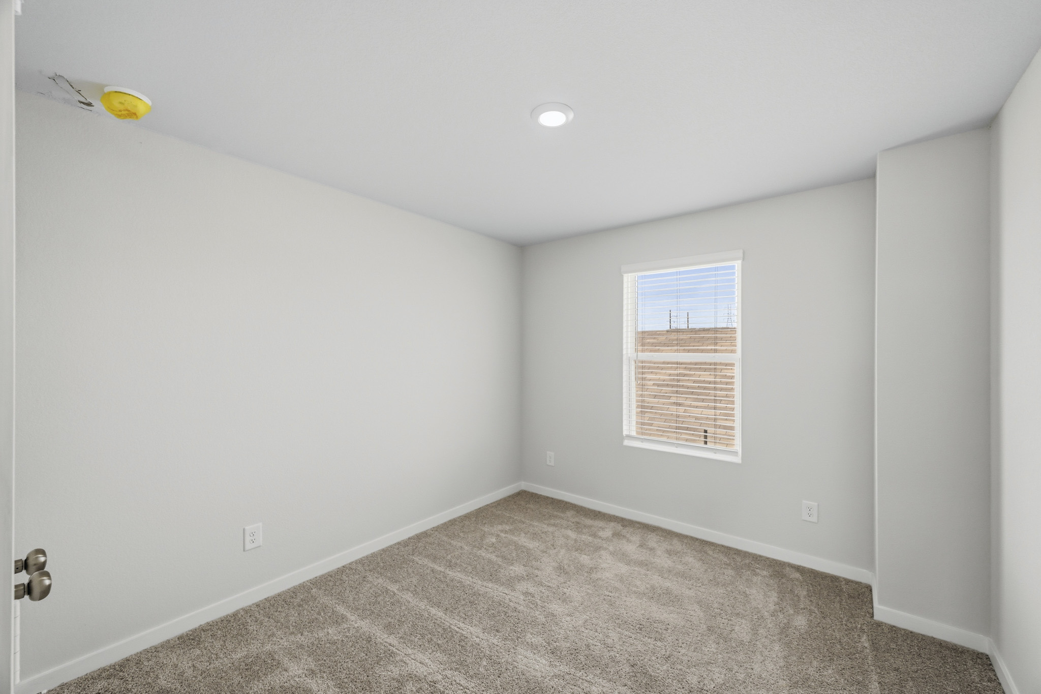 A room with a carpet and a window.