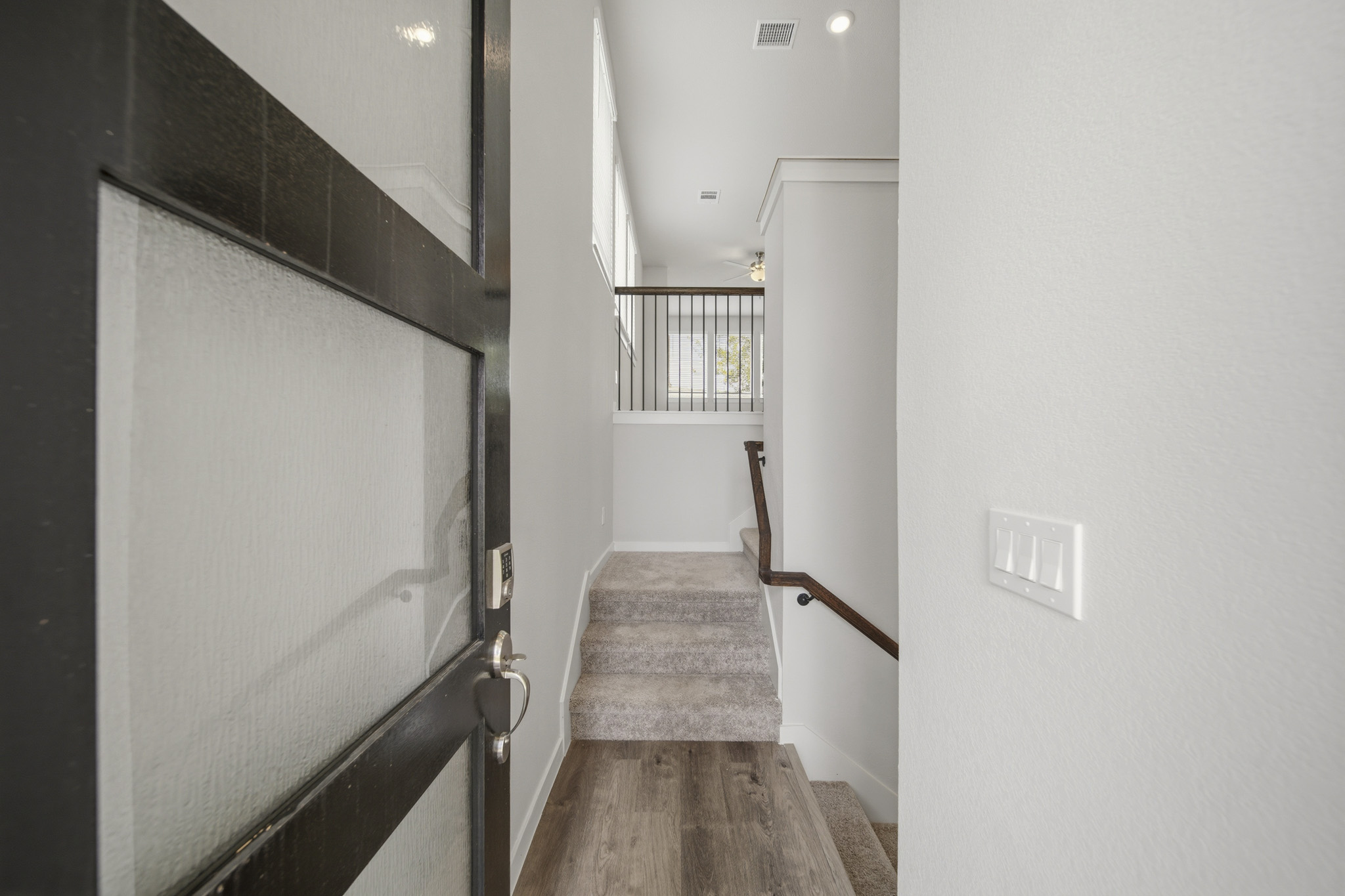 A hallway with a door and a railing.