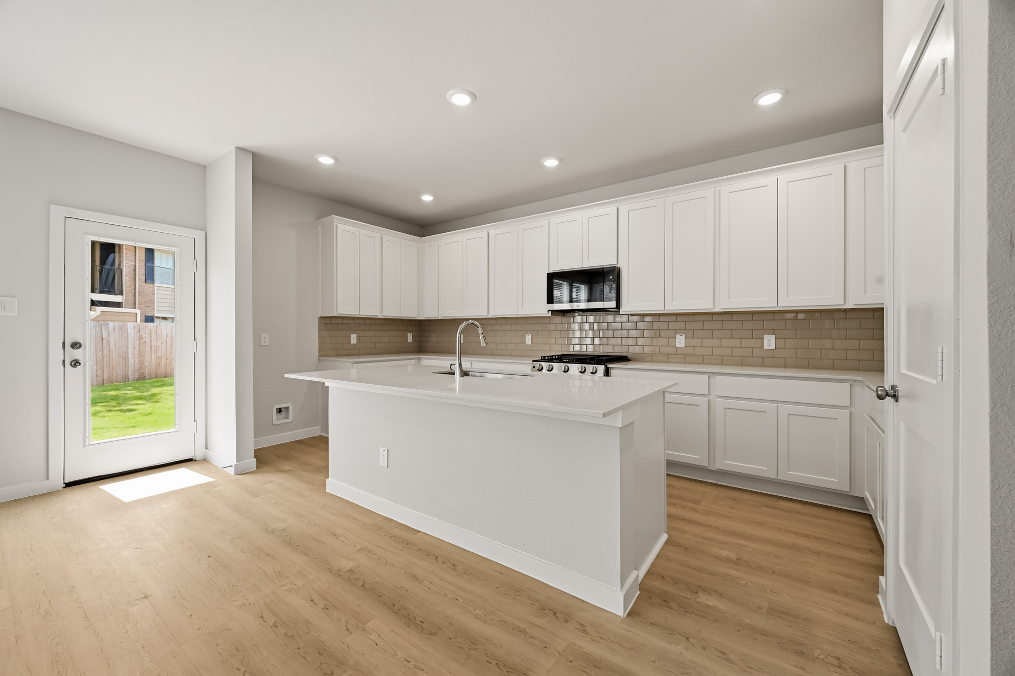 A kitchen with white cabinets.