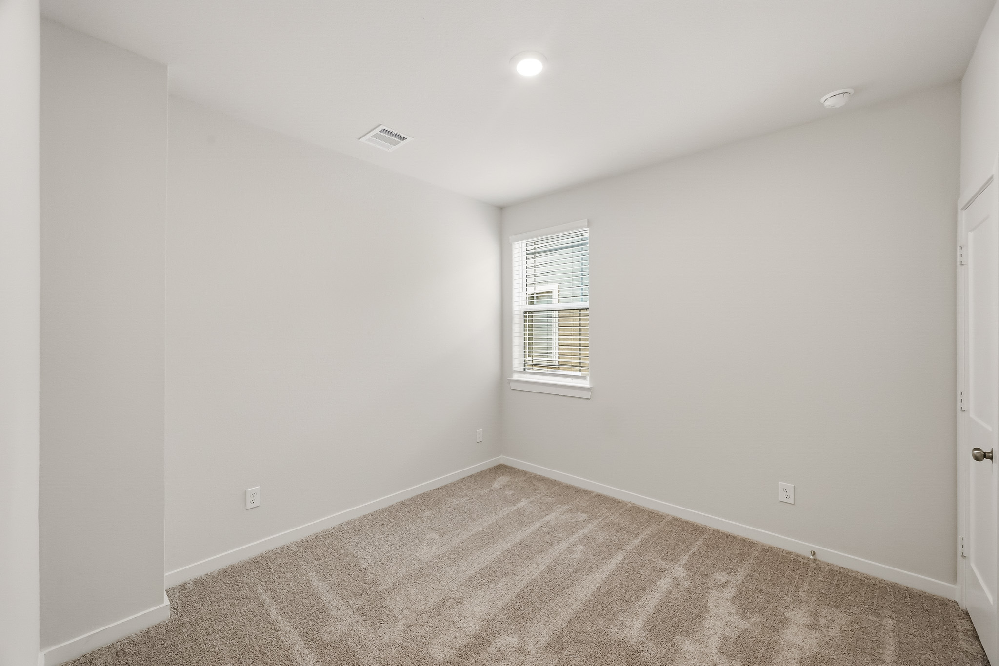 A room with a carpet and a window.