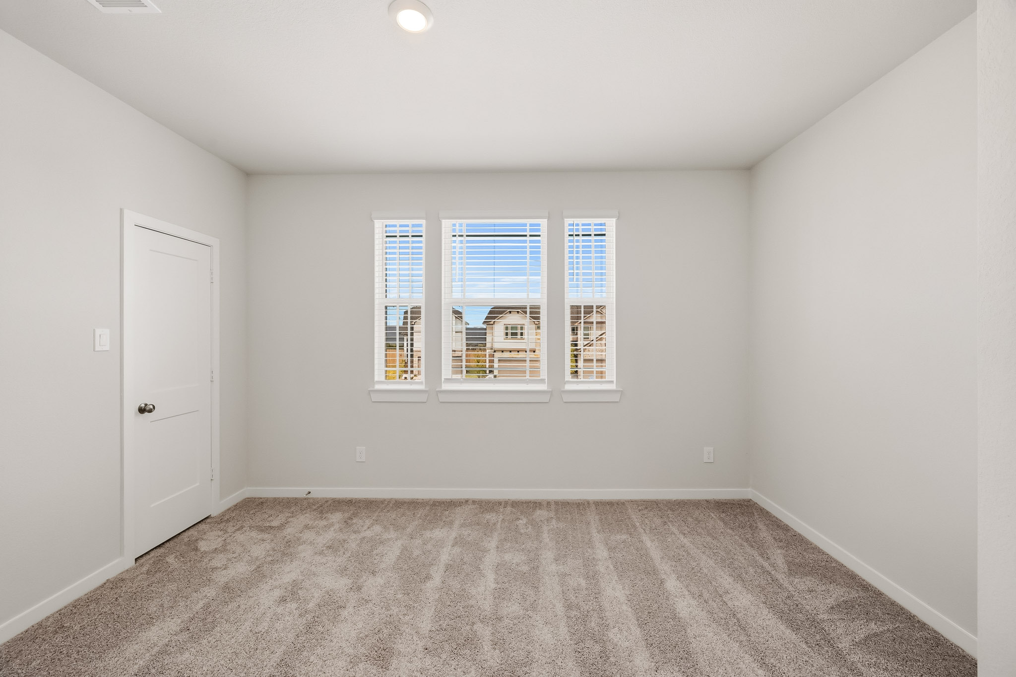 A room with a window and a carpet.