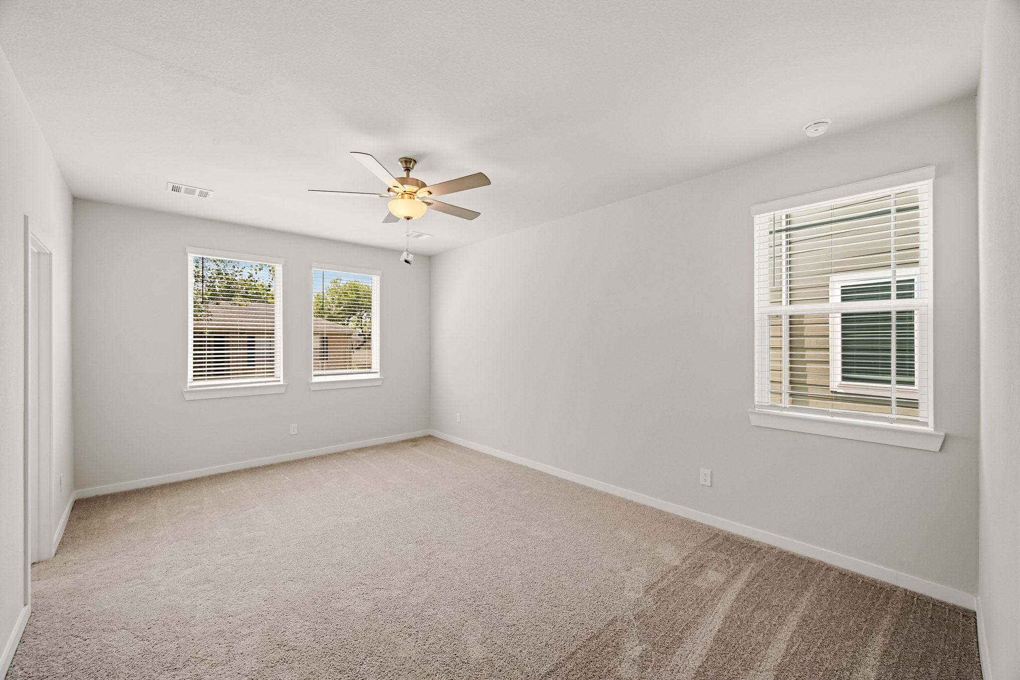 A room with a ceiling fan and a window.