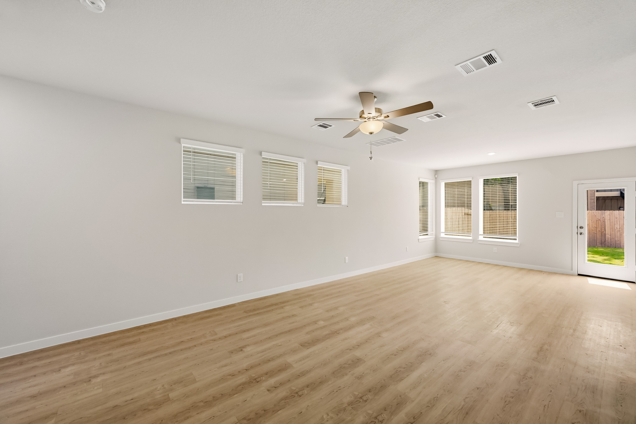 A room with a wood floor and a ceiling fan.