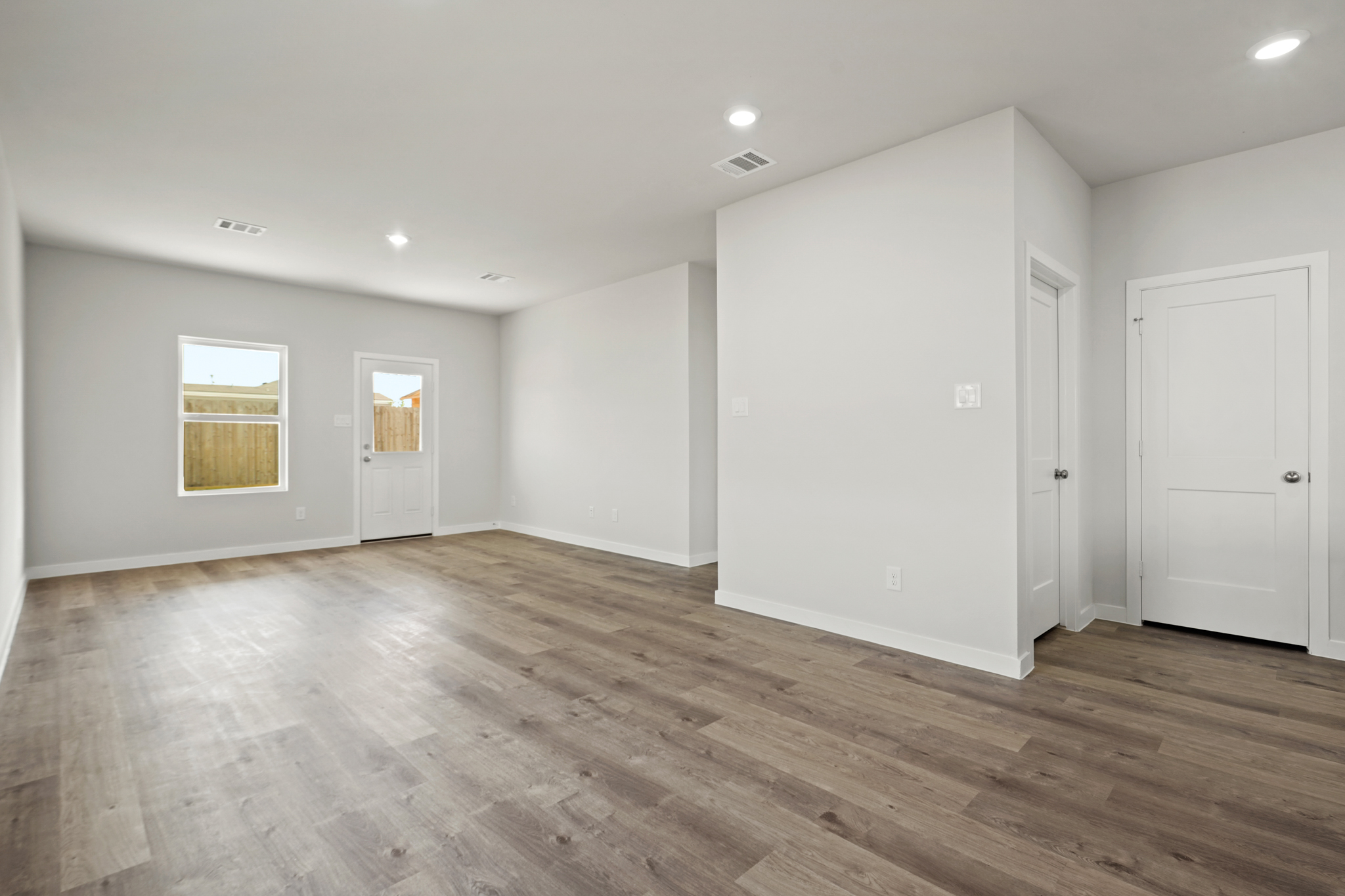 A room with white walls and wood floors.