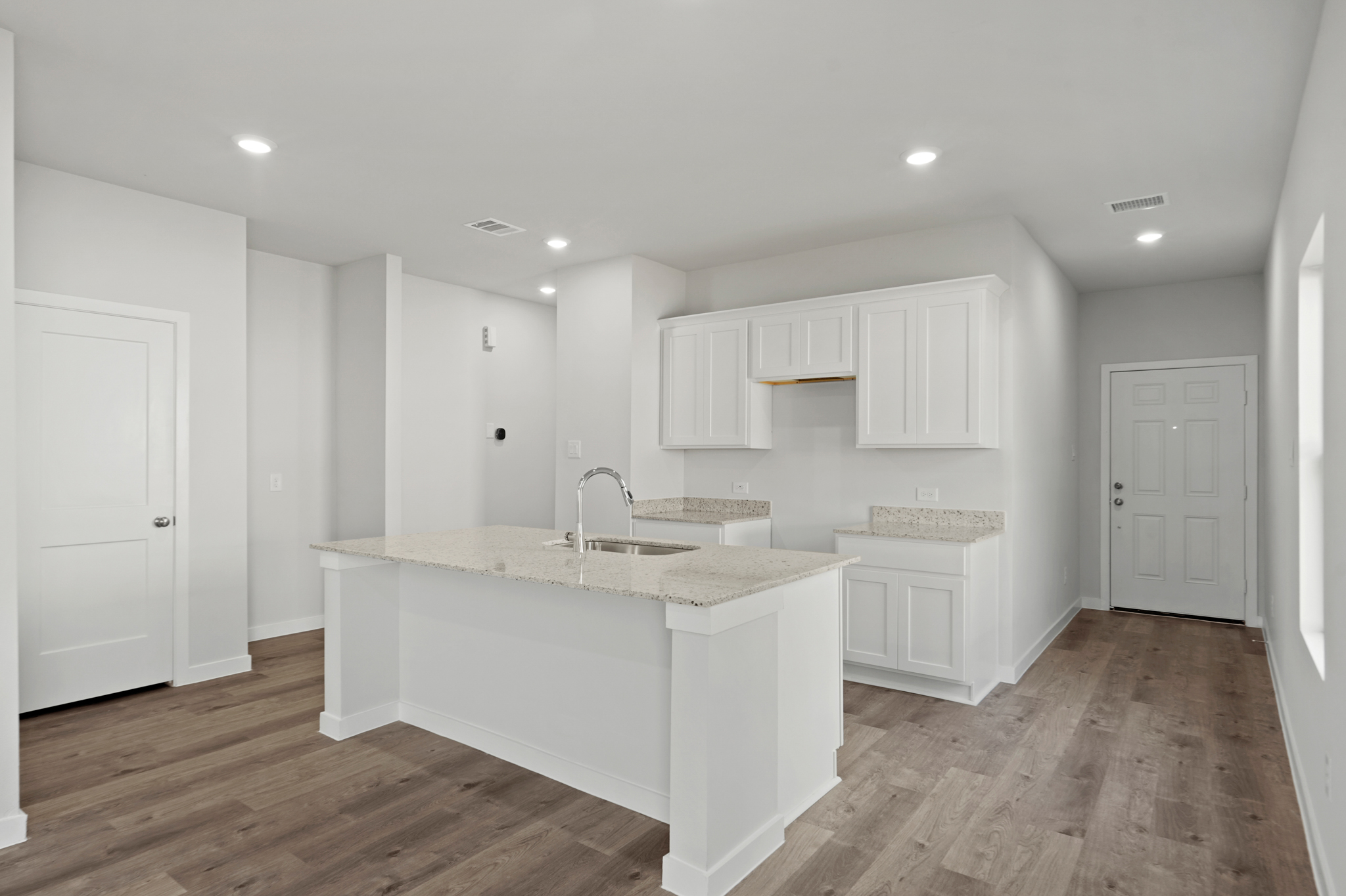 A kitchen with white cabinets.