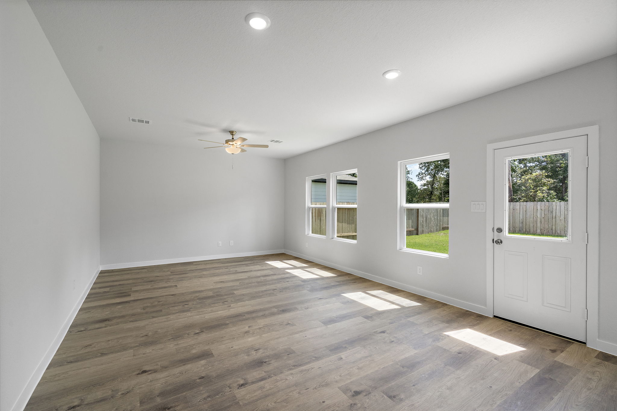 A room with a wood floor and a wood floor with a ceiling fan and a wood floor with.