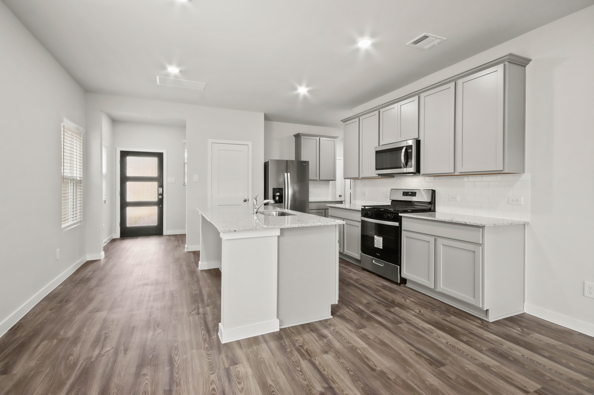 A kitchen with white cabinets.