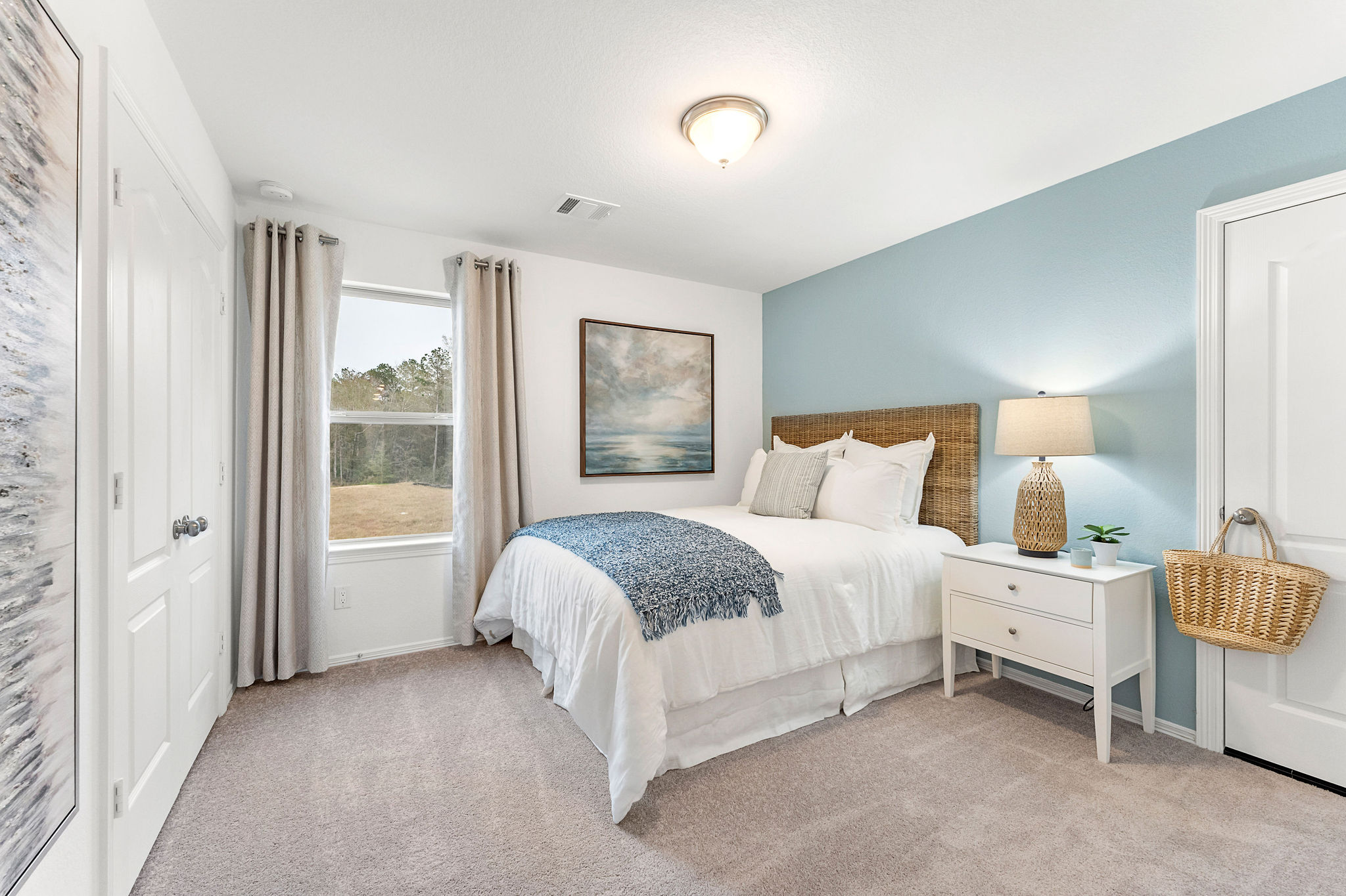 A bedroom with a bed and a lamp.
