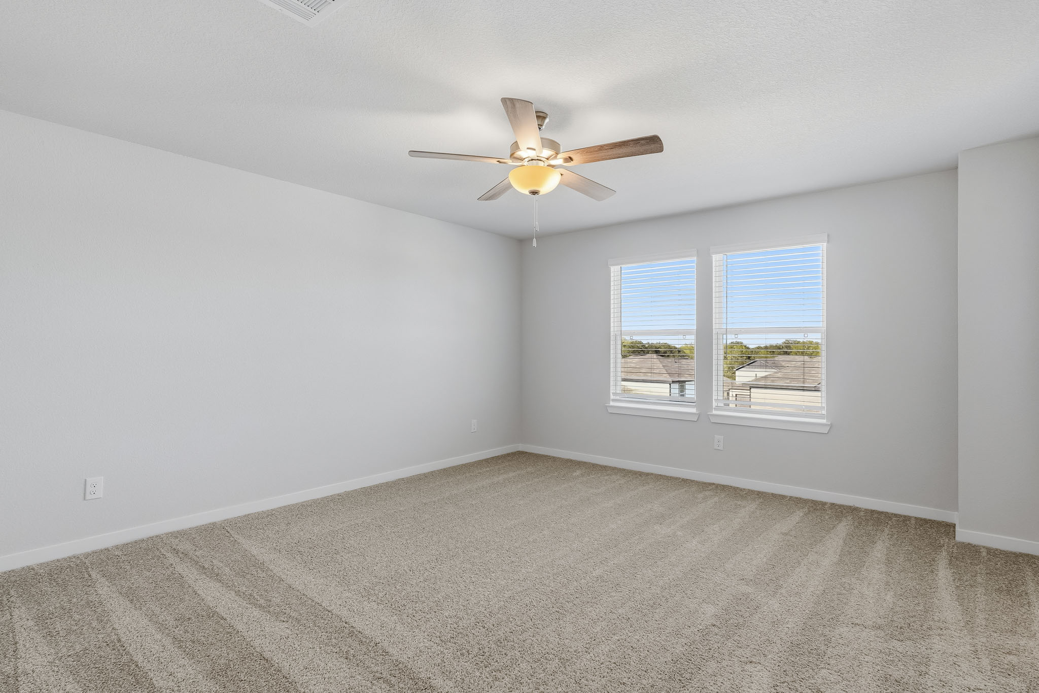 A room with a ceiling fan and a window.