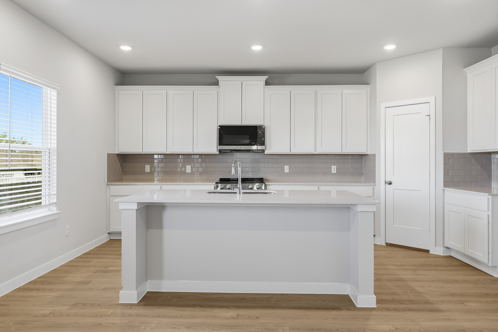 A kitchen with white cabinets.