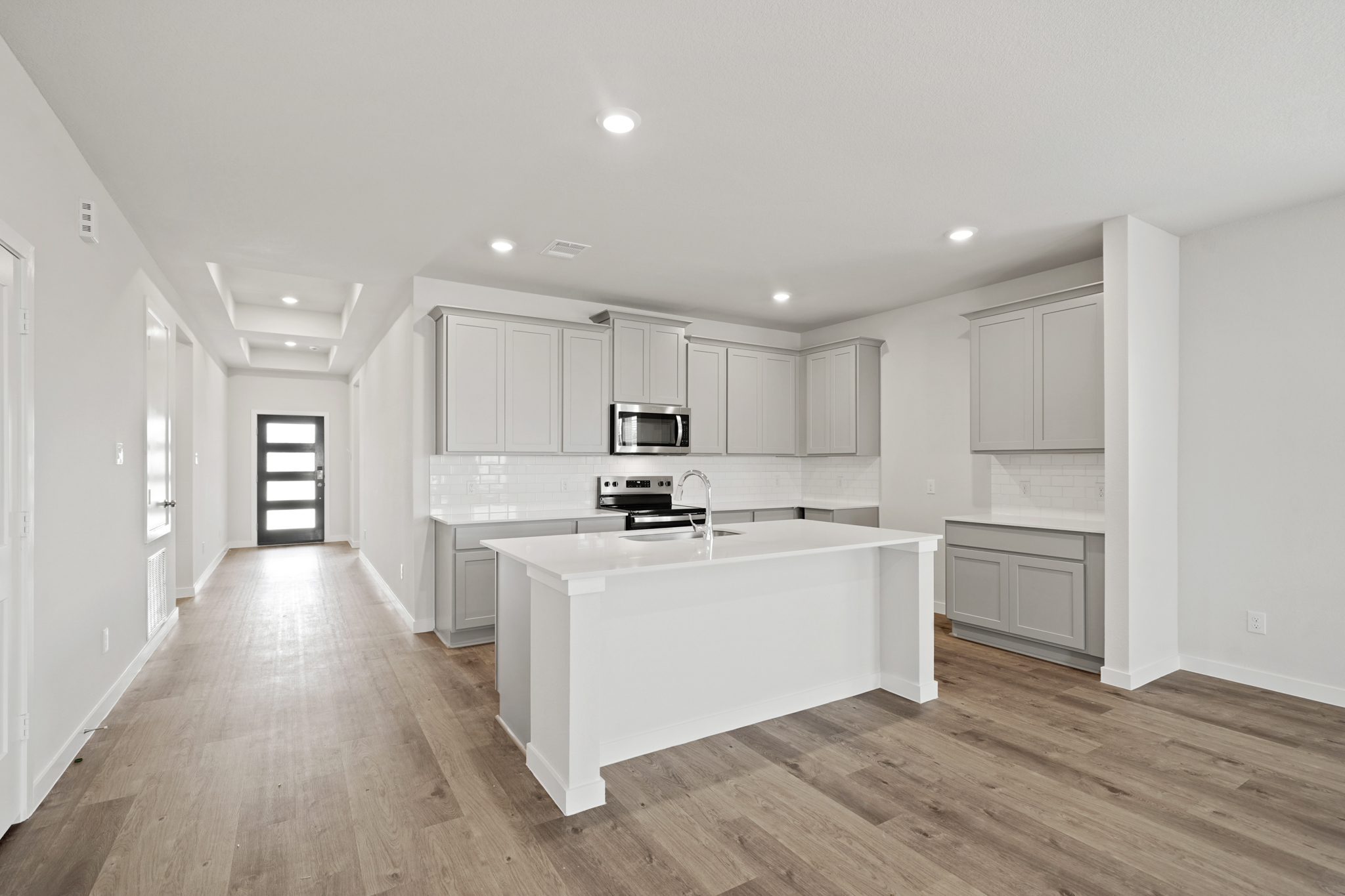 A kitchen with white cabinets.