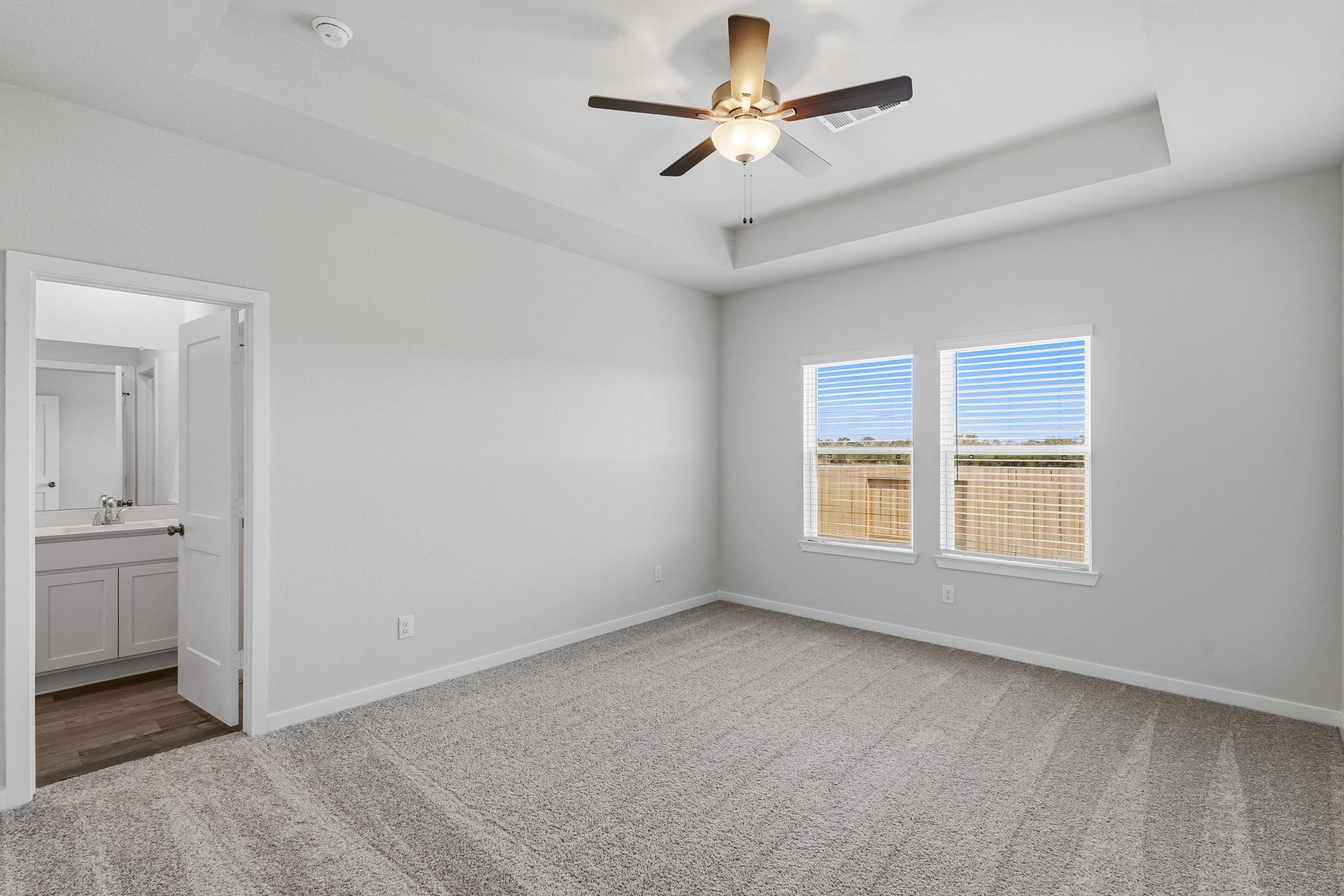 A large room with a ceiling fan and a window.