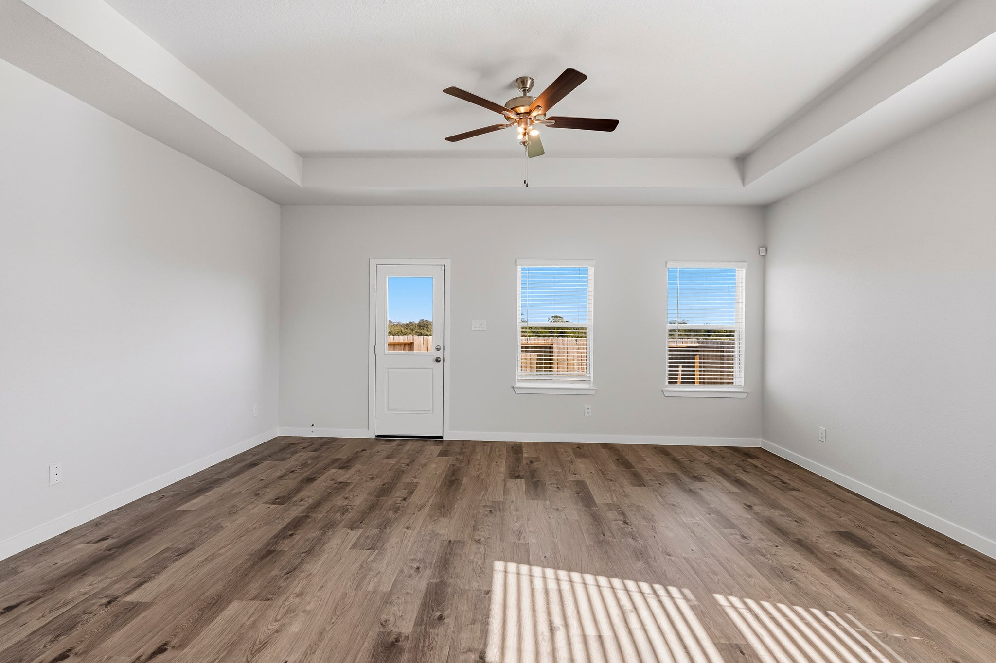 A room with a wood floor and a ceiling fan.