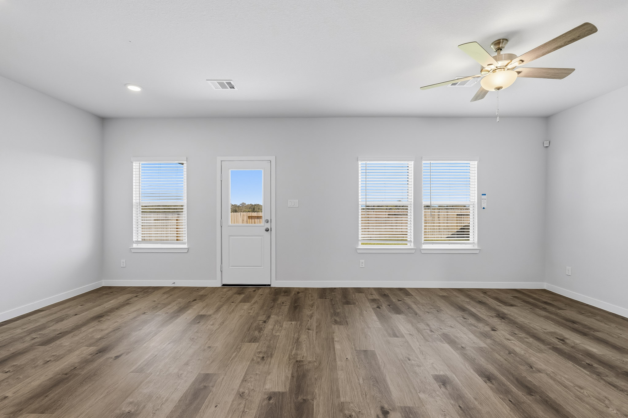A room with a wood floor and a ceiling fan.