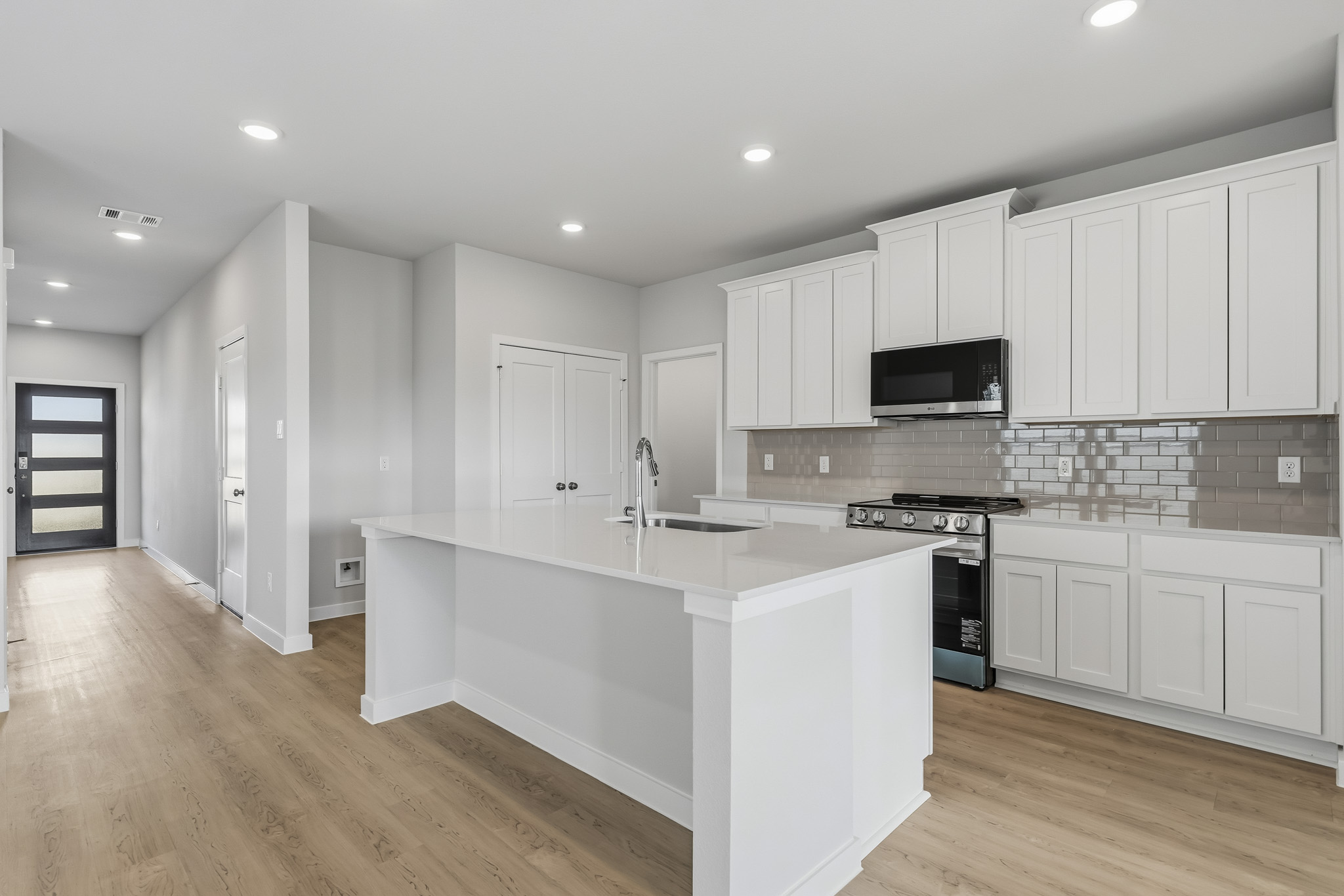 A kitchen with white cabinets.