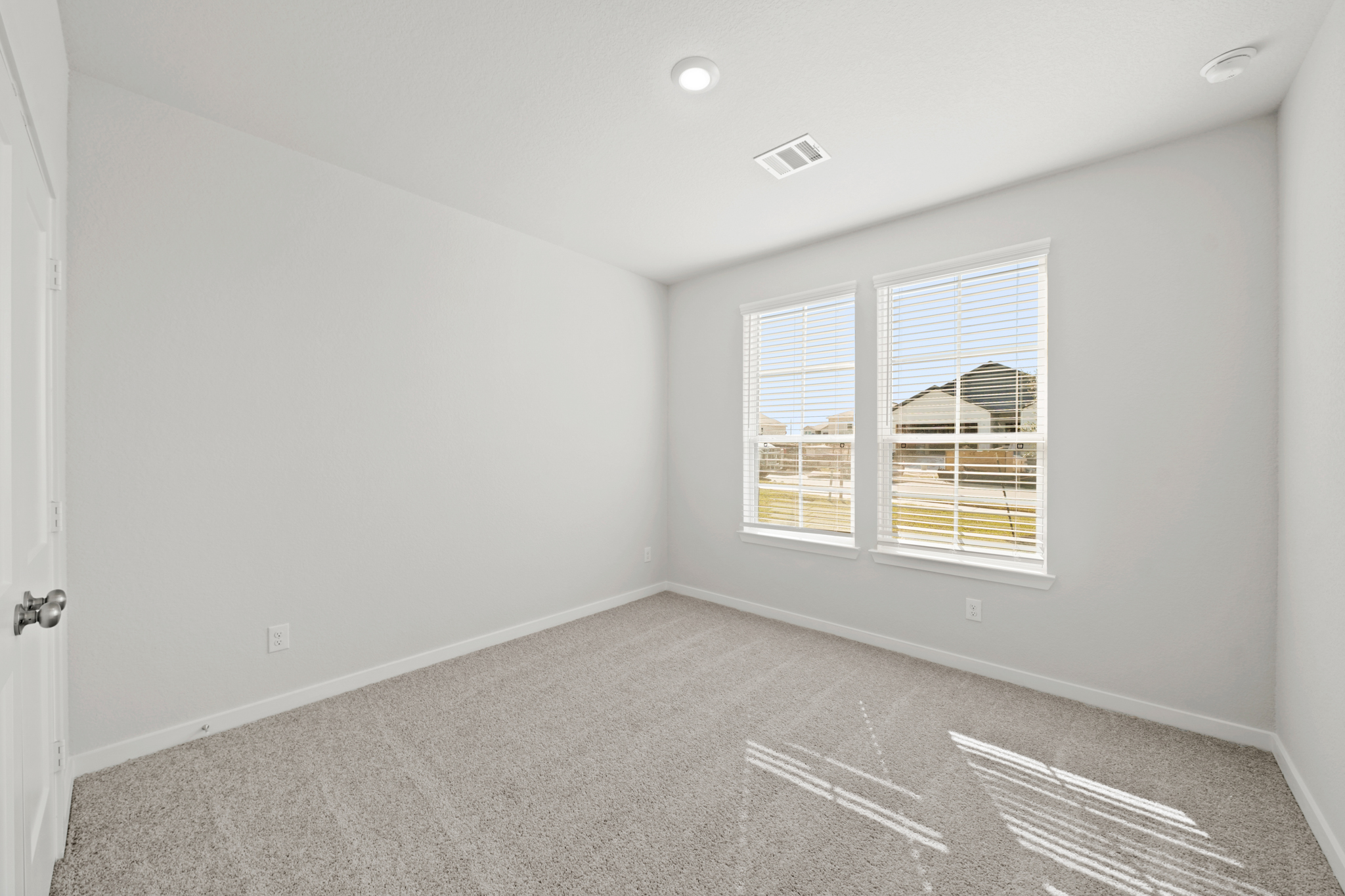 A room with a window and a carpet.