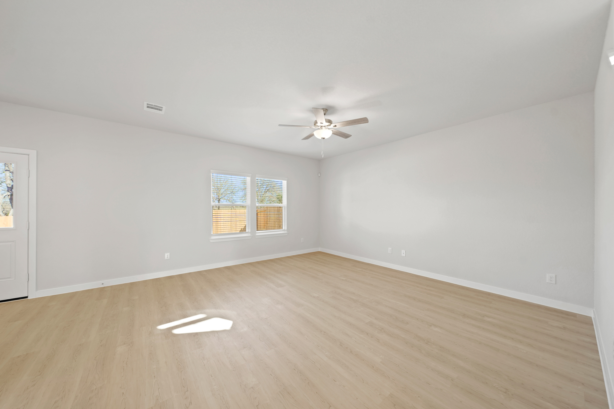 A room with a wood floor and a ceiling fan.