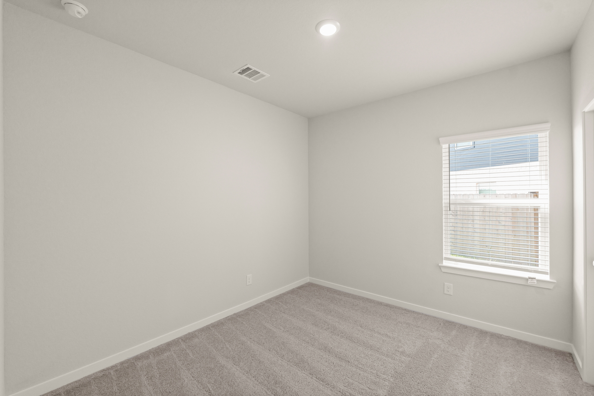 A room with a window and a carpet.