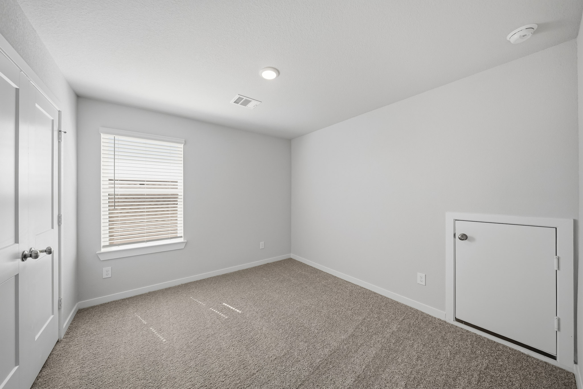 A room with white walls and a door.