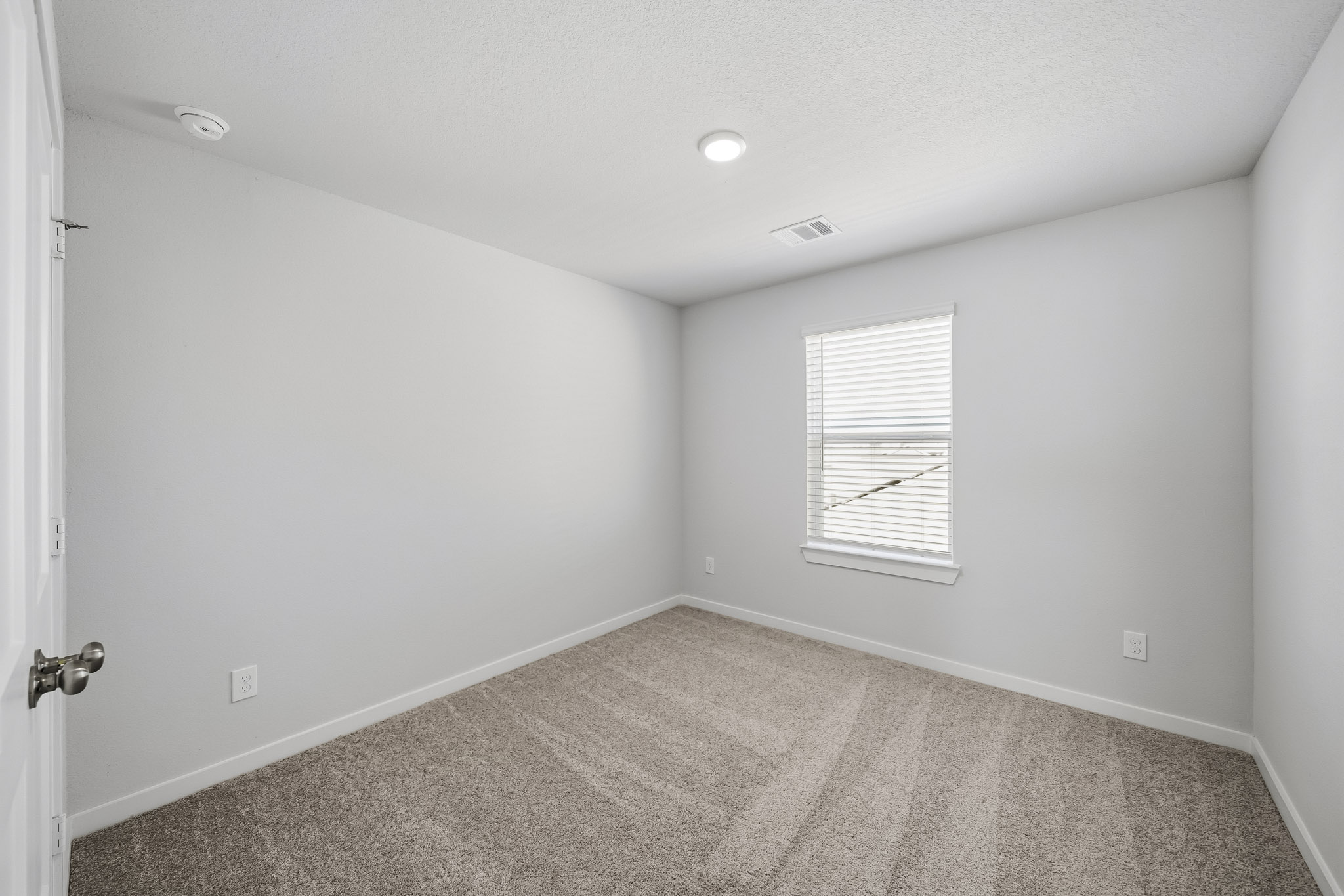 A room with a carpet and a door.