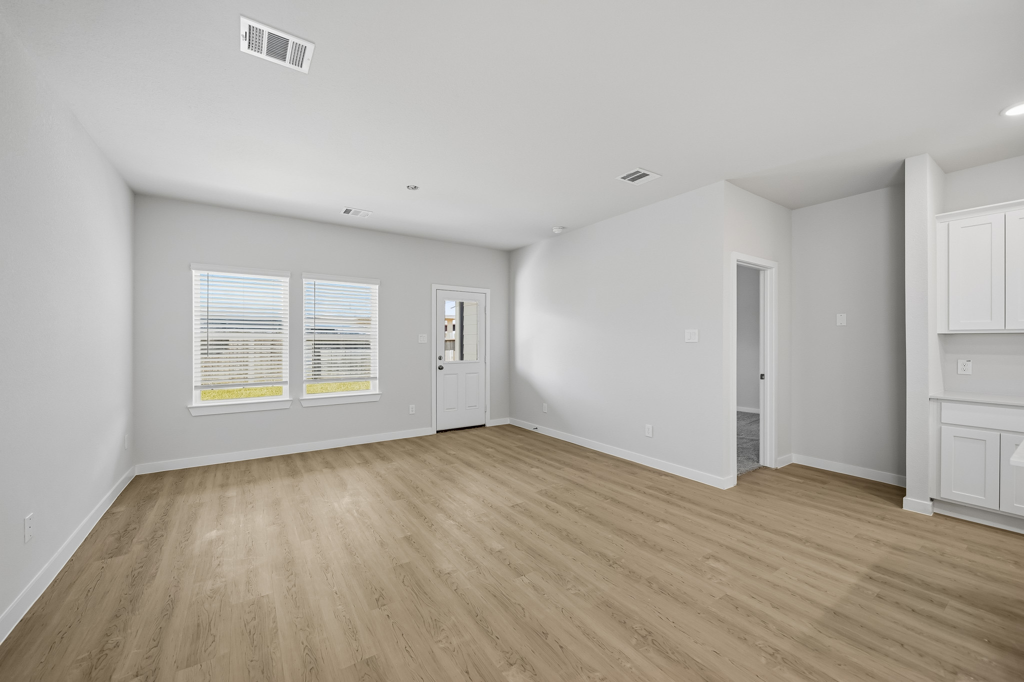A room with white walls and wood floors.