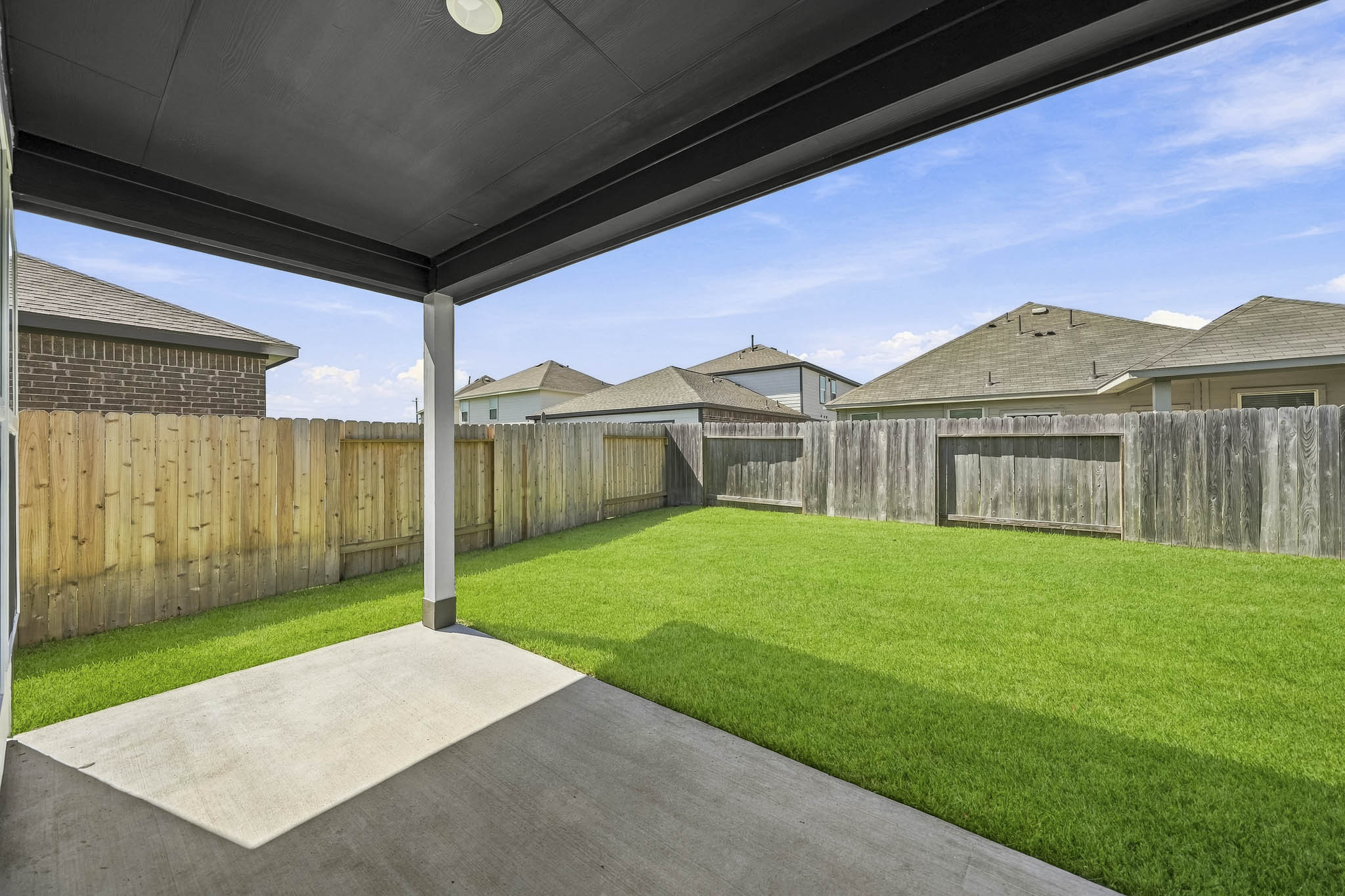 A fenced in yard with a house in the background.