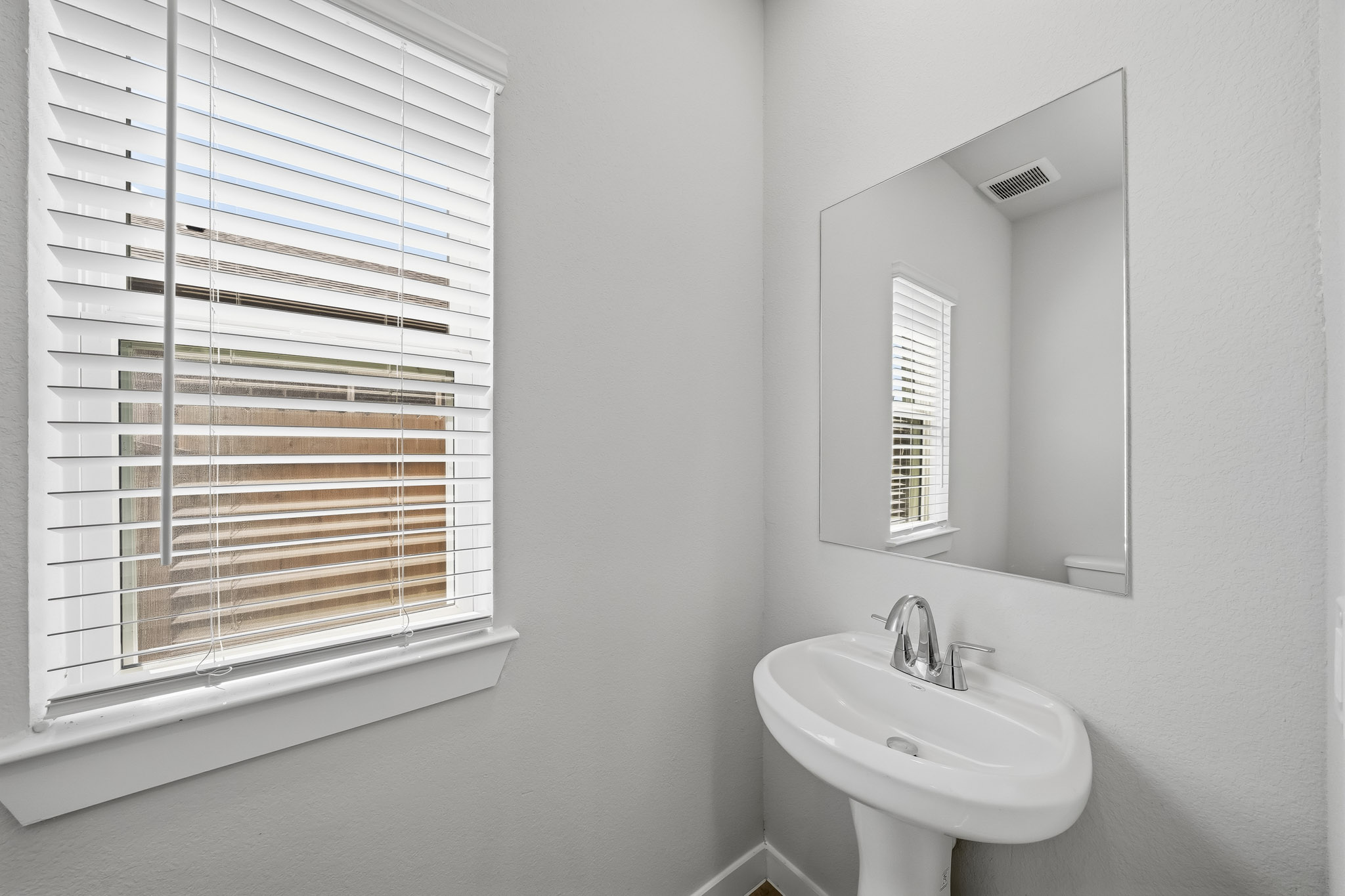 A bathroom with a sink and a mirror.