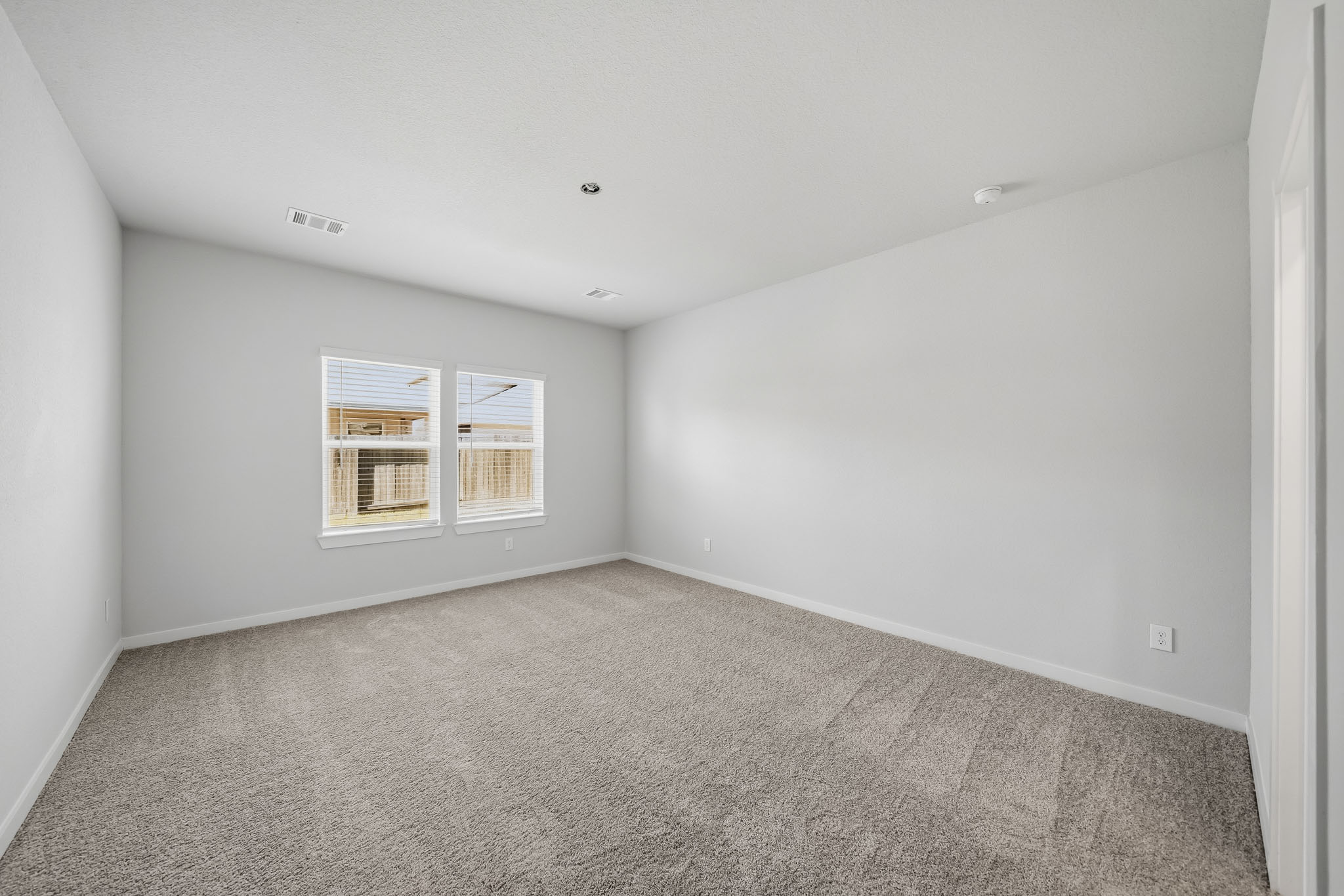 A room with a carpet and a window.